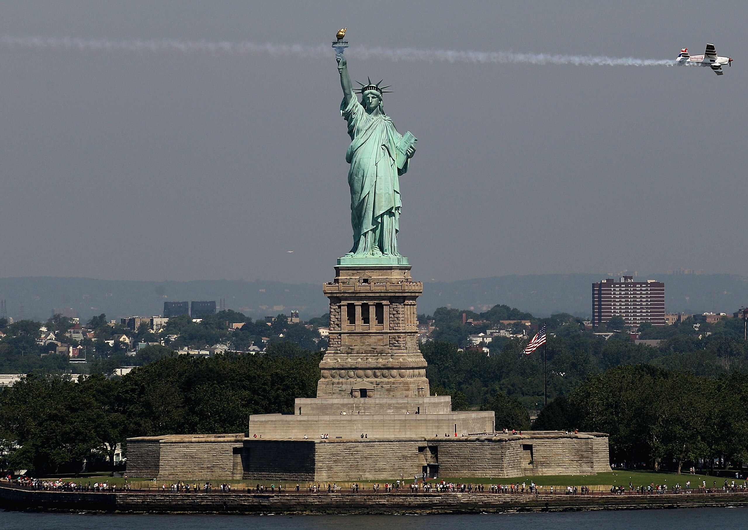 NEW YORK - JUNE 18:  Paul Bonhomme of Great Britain flies past the Statue of Liberty during the Red Bull Air Race New York Training Day on June 18, 2010 in New Jersey.  (Photo by Hamish Blair/Getty Images for Red Bull Air Race)