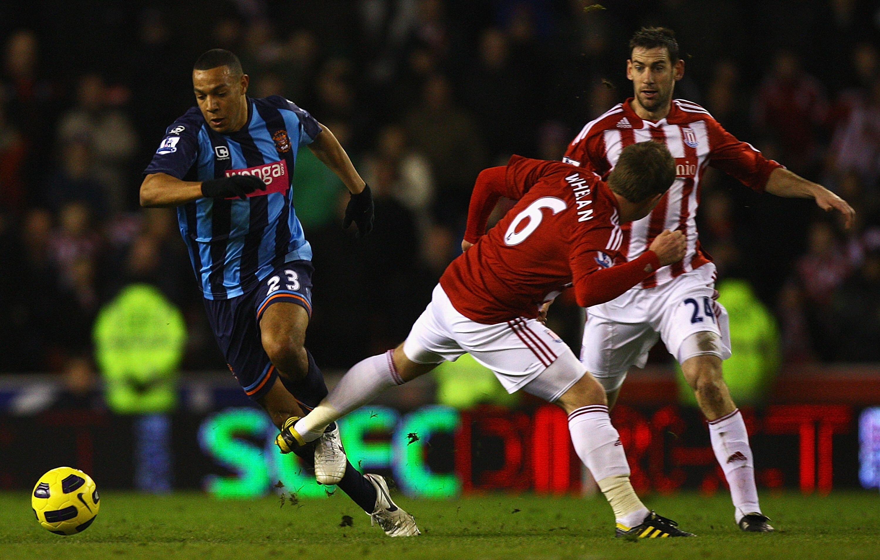 STOKE ON TRENT, ENGLAND - DECEMBER 11:  Matt Phillips of Blackpool beats the tackle from Glenn Whelan of Stoke during the Barclays Premier League match between Stoke City and Blackpool at Britannia Stadium on December 11, 2010 in Stoke on Trent, England.