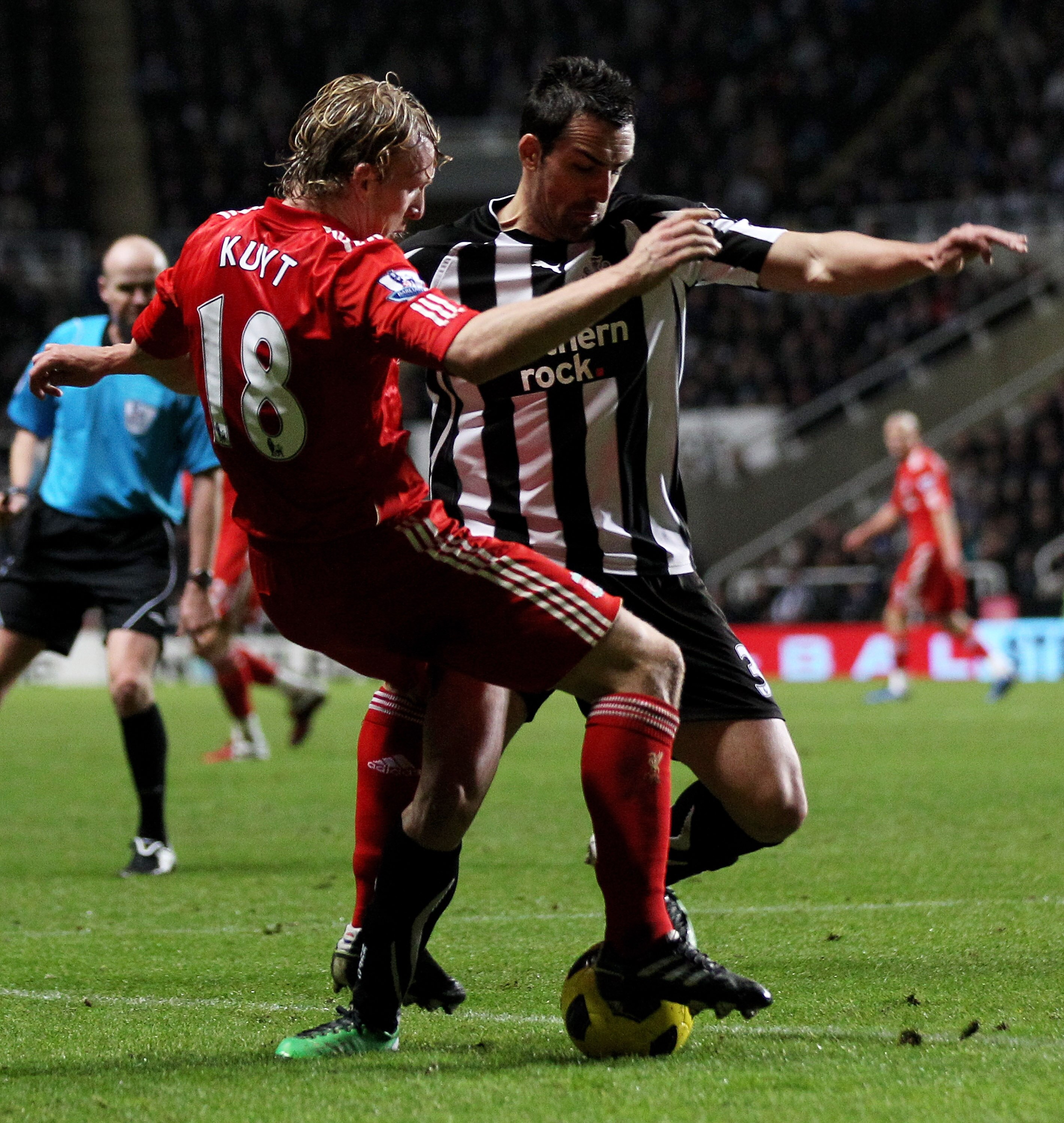 NEWCASTLE UPON TYNE, ENGLAND - DECEMBER 11:  Dirk Kuyt of Liverpool tangles with Jose Enrique of Newcastle United during the Barclays Premier League match between Newcastle United and Liverpool at St James' Park on December 11, 2010 in Newcastle, England.