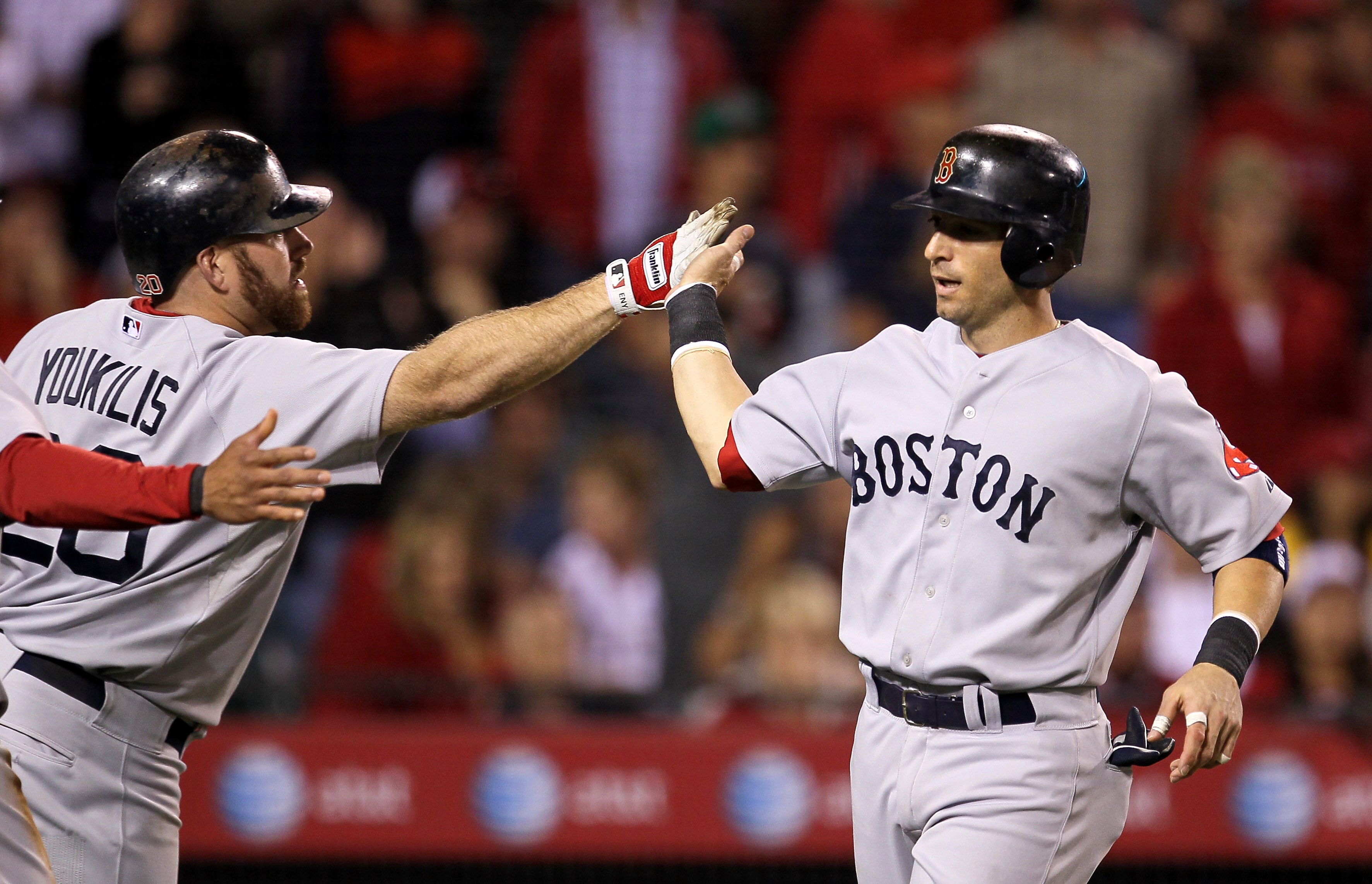 ANAHEIM, CA - JULY 27: Marco Scutaro #30 of the Boston Red Sox is greeted by on deck batter Kevin Youkilis #20 after scoring  run in the seventh inning against the Los Angeles Angels of Anaheim on July 27, 2010 at Angel Stadium in Anaheim, California. (Ph