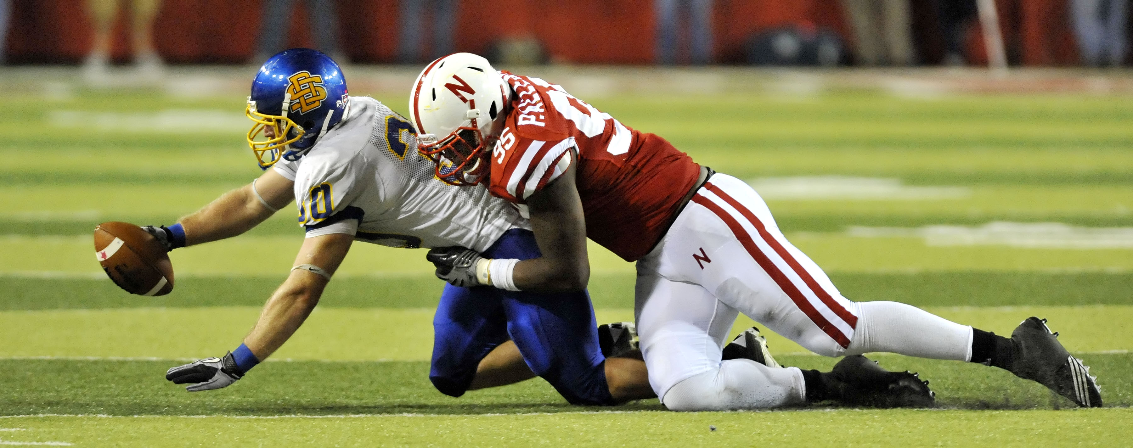 LINCOLN, NB - SEPTEMBER 25: Defensive end Pierre Allen #95 of the Nebraska Cornuskers brings down  running back Kyle Minett #30 of the South Dakota State Jackrabbits during second half action  of their game at Memorial Stadium on September 25, 2010 in Lin