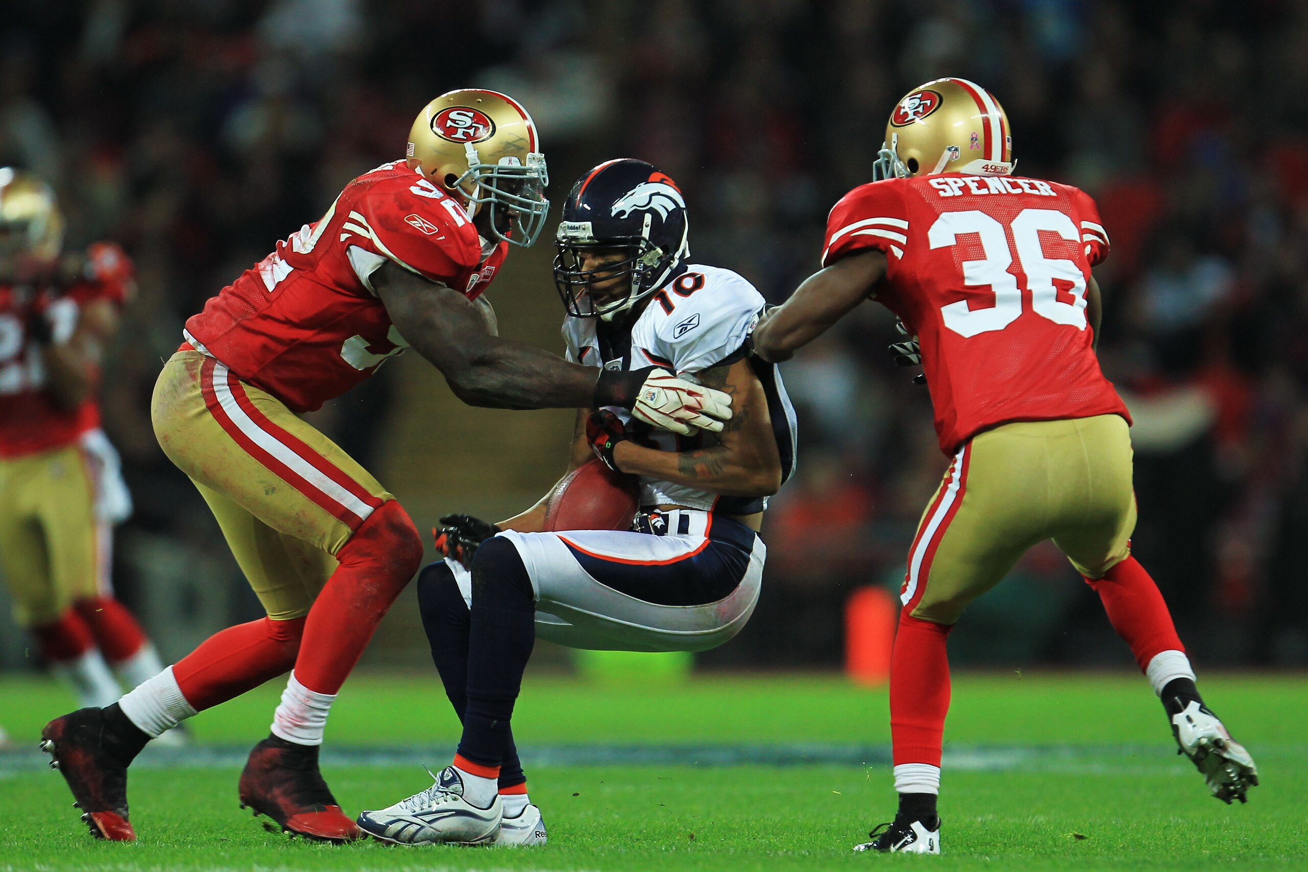 LONDON, ENGLAND - OCTOBER 31:  Jabar Gaffney #10 of Denver Broncos is tackled by Patrick Willis #52 and Shawntae Spencer #36 of San Francisco 49ers during the NFL International Series match between Denver Broncos and San Francisco 49ers at Wembley Stadium