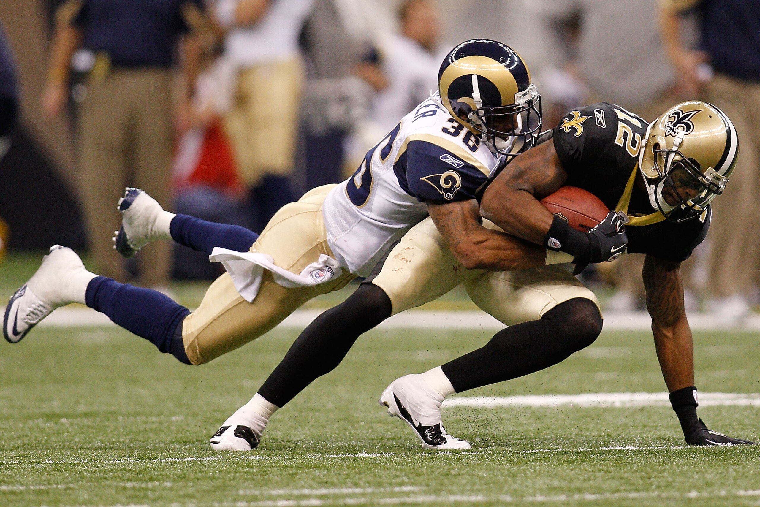 NEW ORLEANS, LA - DECEMBER 12:  Marques Colston #12 of the New Orleans Saints is tackled by Quincy Butler #36 of the St. Louis Rams at the Louisiana Superdome on December 12, 2010 in New Orleans, Louisiana.  (Photo by Chris Graythen/Getty Images)