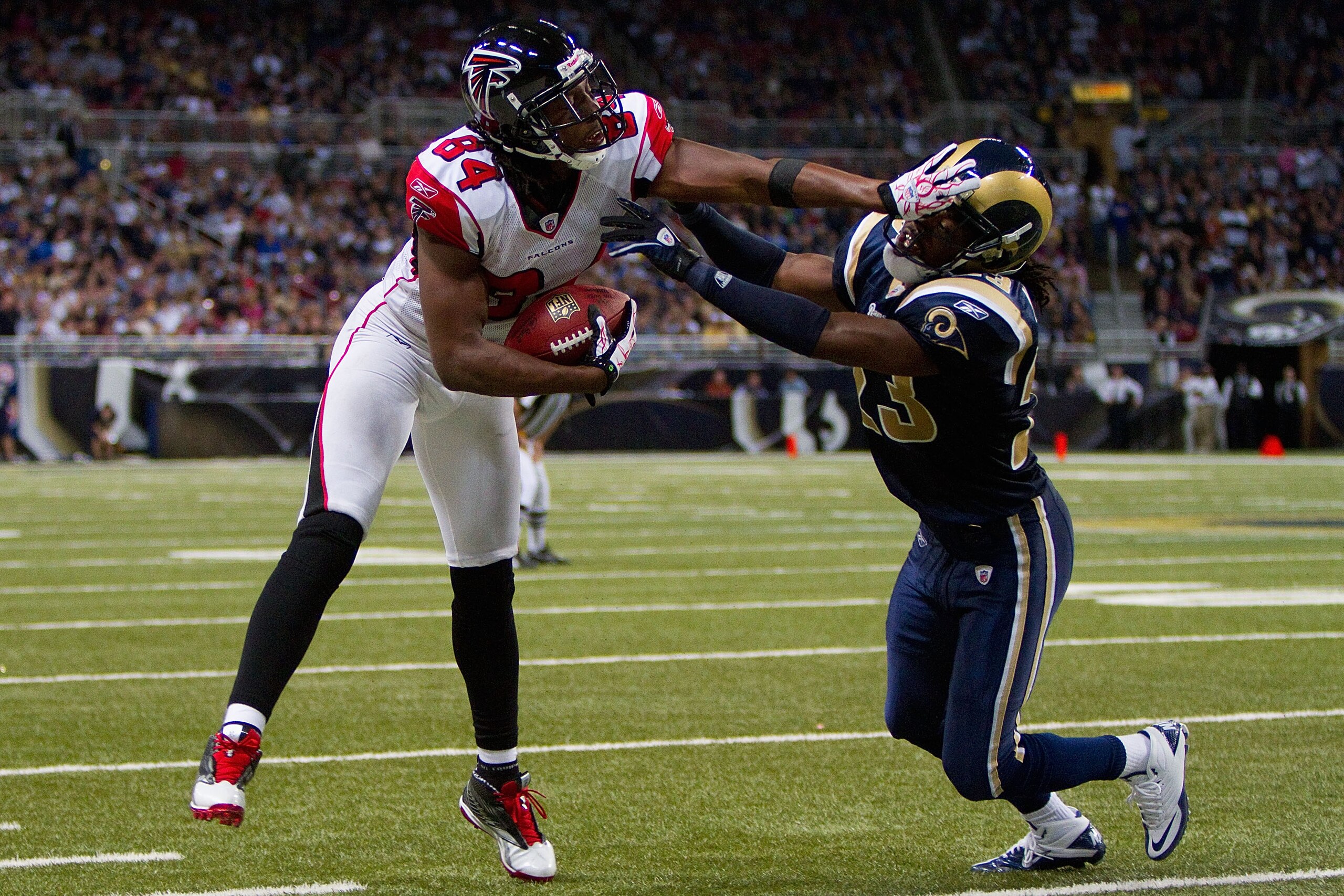 ST. LOUIS - NOVEMBER 21: Roddy White #84 of the Atlanta Falcons stiff arms Jerome Murphy #23 of the St. Louis Rams at the Edward Jones Dome on November 21, 2010 in St. Louis, Missouri.  The Falcons beat the Rams 34-17.  (Photo by Dilip Vishwanat/Getty Ima