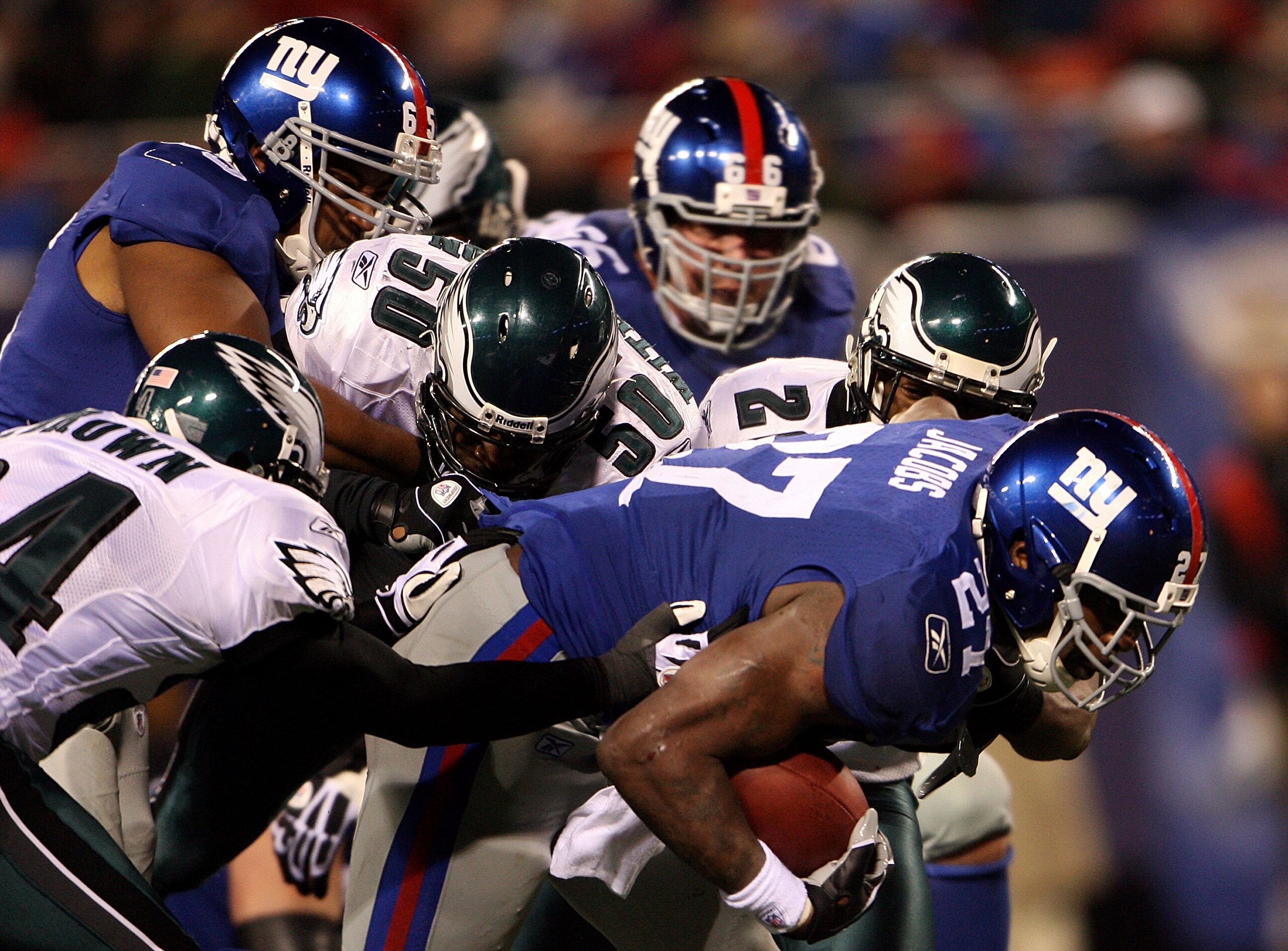 EAST RUTHERFORD, NJ - DECEMBER 13:  Brandon Jacobs #27 of the New York Giants runs the ball against Sheldon Brown #24 and Will Witherspoon #50 of the Philadelphia Eagles at Giants Stadium on December 13, 2009 in East Rutherford, New Jersey.  (Photo by Mic