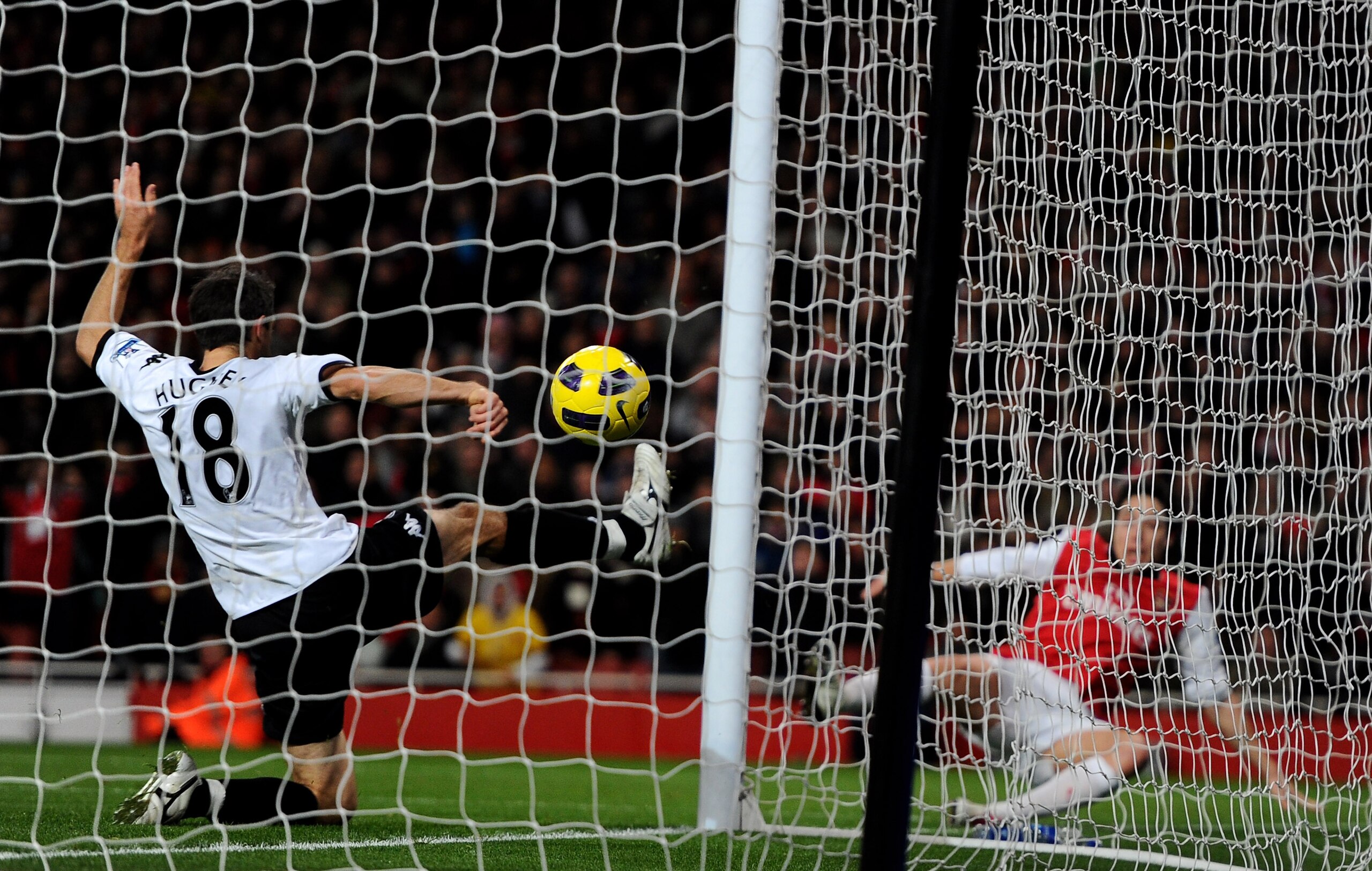 LONDON, ENGLAND - DECEMBER 04:  Samir Nasri (R) of Arsenal scores the second goal past Aaron Hughes of Fulham during the Barclays Premier League match between Arsenal and Fulham at the Emirates Stadium on December 4, 2010 in London, England.  (Photo by Mi