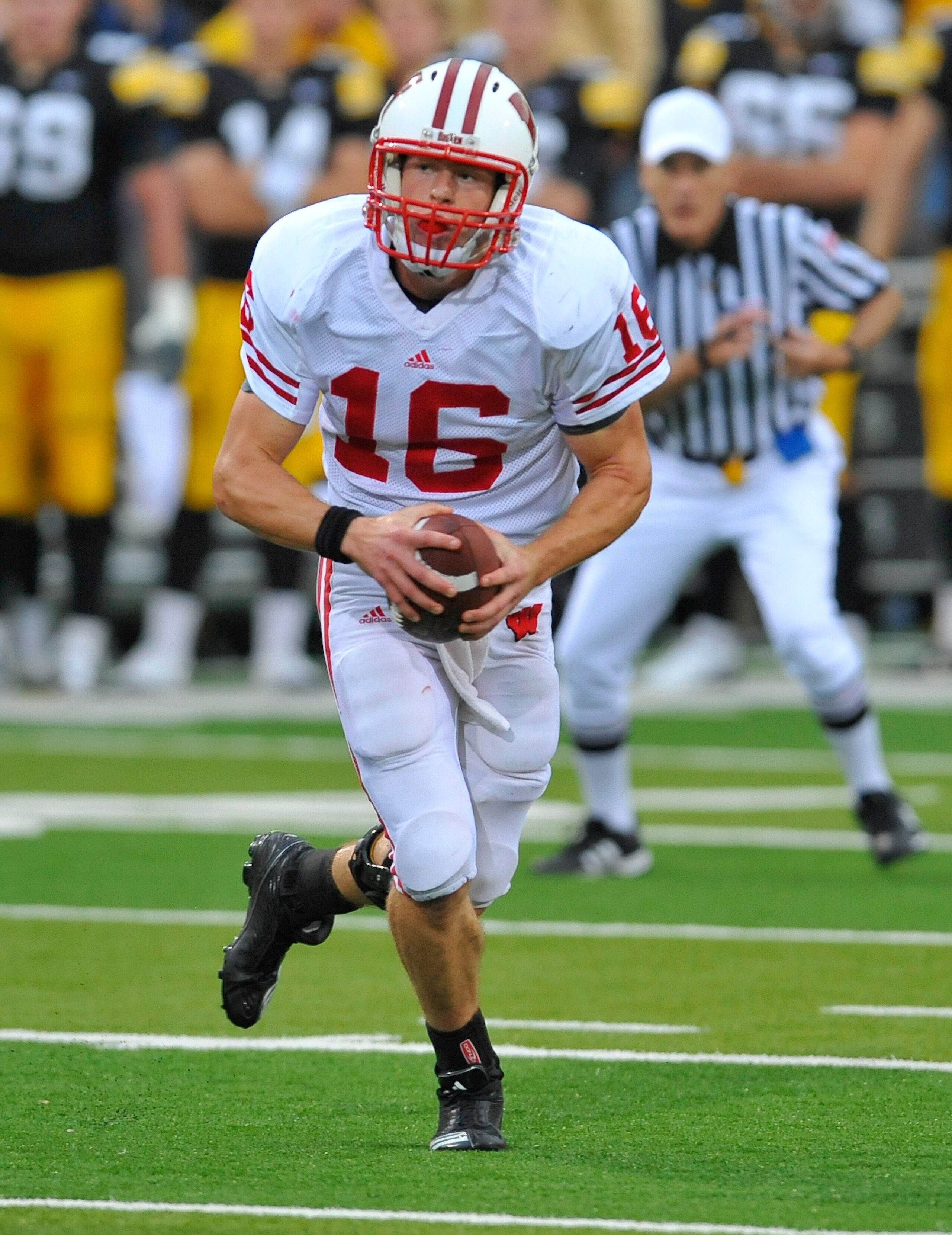 IOWA CITY, IA - OCTOBER 23- Quarterback Scott Tolzien #16 of the Wisconsin Badgers scrambles under pressure from the University of Iowa Hawkeyes during the first half of play at Kinnick Stadium on October 23, 2010 in Iowa City, Iowa. Wisconsin won 31-30 o