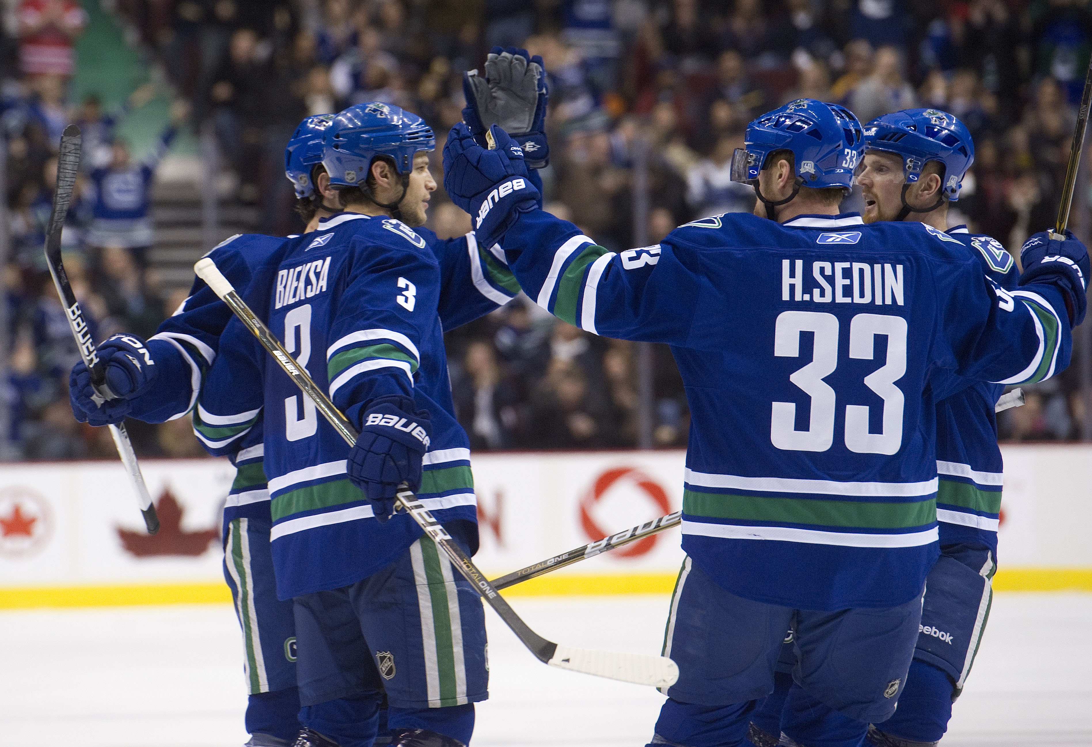 VANCOUVER, CANADA - DECEMBER 5: Kevin Bieksa #3 of the Vancouver Canucks is congratulated by Keith Ballard #4, Henrik Sedin #33 and Daniel Sedin #22 after scoring against the St Louis Blues during the second period in NHL action on December 05, 2010 at Ro