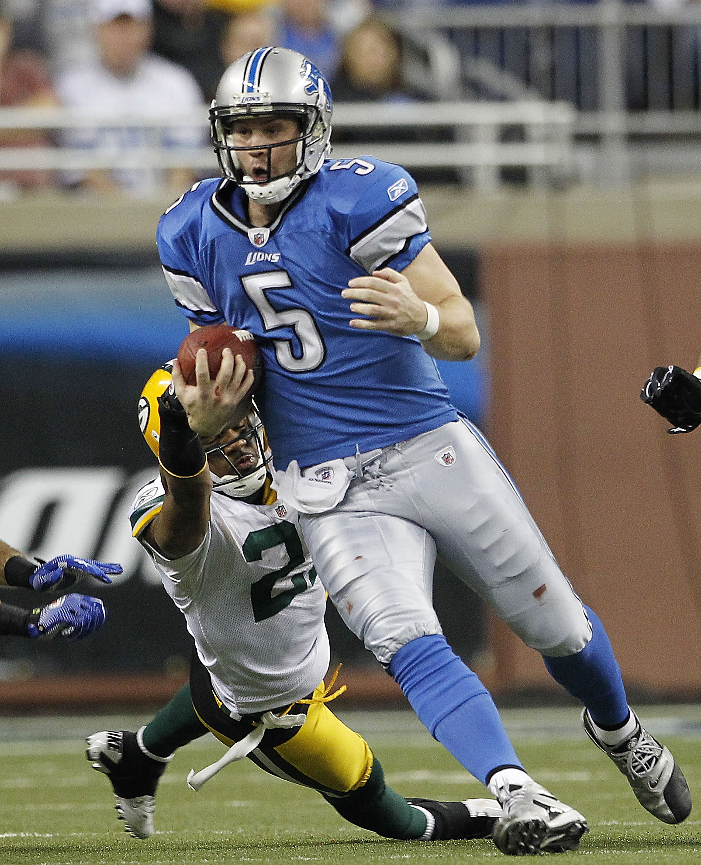 DETROIT - DECEMBER 12: Drew Stanton #5 of the Detroit Lions runs for a first down as Charles Woodson #21 of the Green Bay Packers attempts to make the stop during the game at Ford Field on December 12, 2010 in Detroit, Michigan. The Lions defeated the Pac