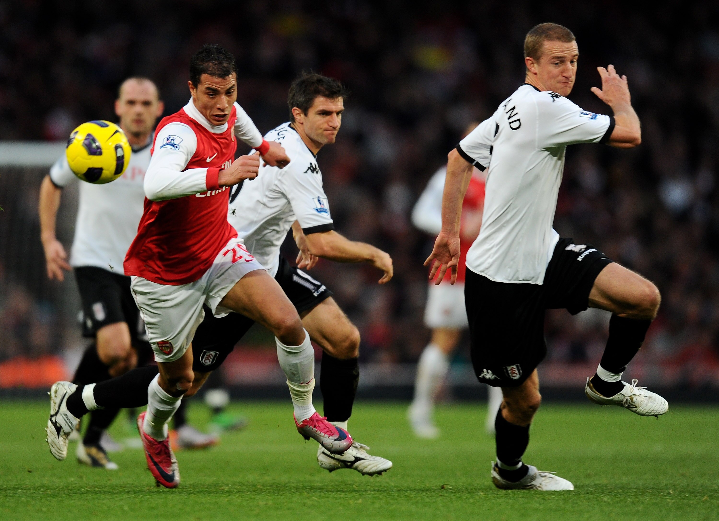 LONDON, ENGLAND - DECEMBER 04:  Marouane Chamakh of Arsenal takes the ball past the Fulham defense during the Barclays Premier League match between Arsenal and Fulham at the Emirates Stadium on December 4, 2010 in London, England.  (Photo by Mike Hewitt/G