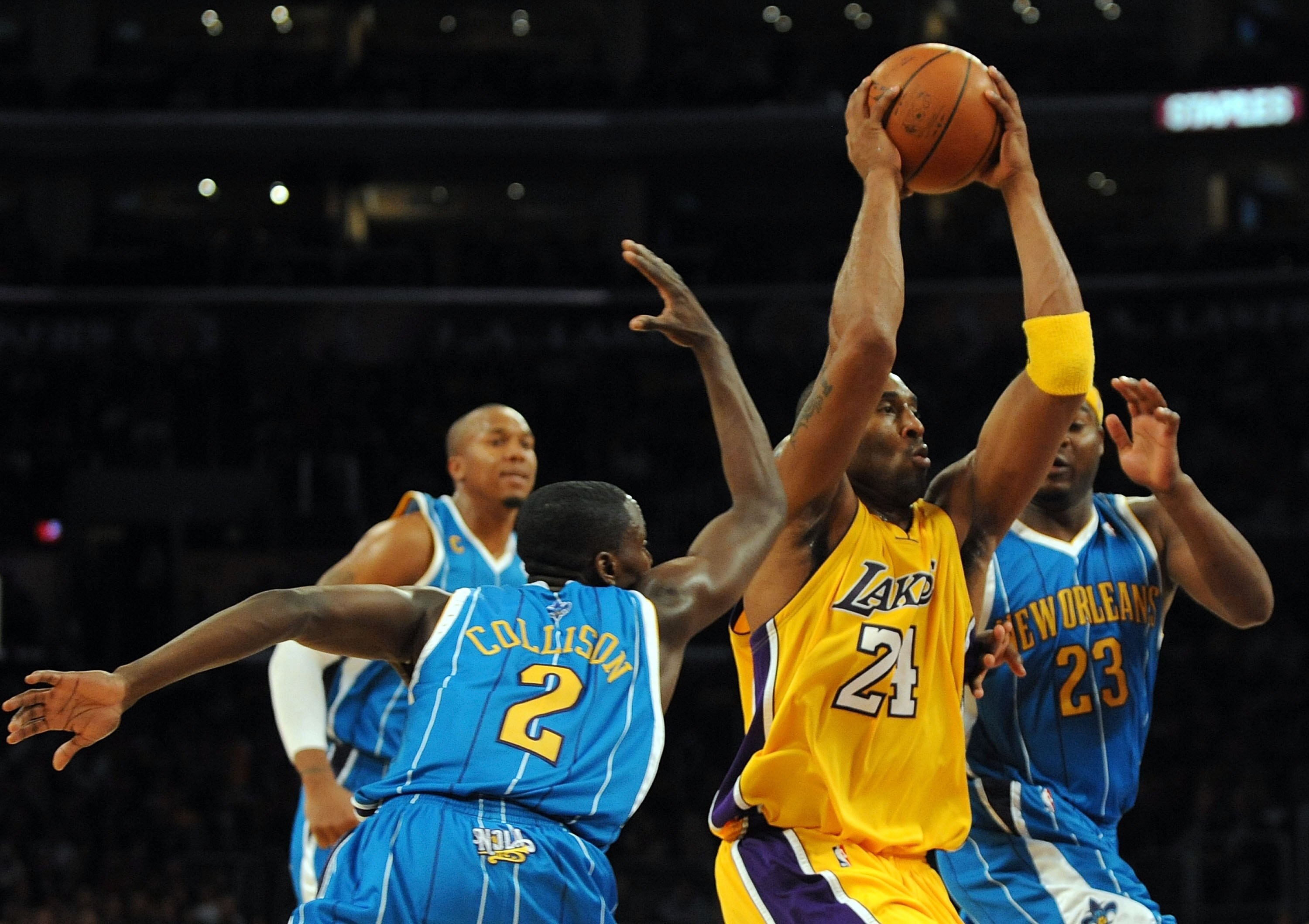 LOS ANGELES, CA - DECEMBER 01:  Kobe Bryant #24 of the Los Angeles Lakers attempts a layup in front of  Devin Brown #23 and David West #30 and Darren Collison #2 of the New Orleans Hornets during the first half at Staples Center on December 1, 2009 in Los