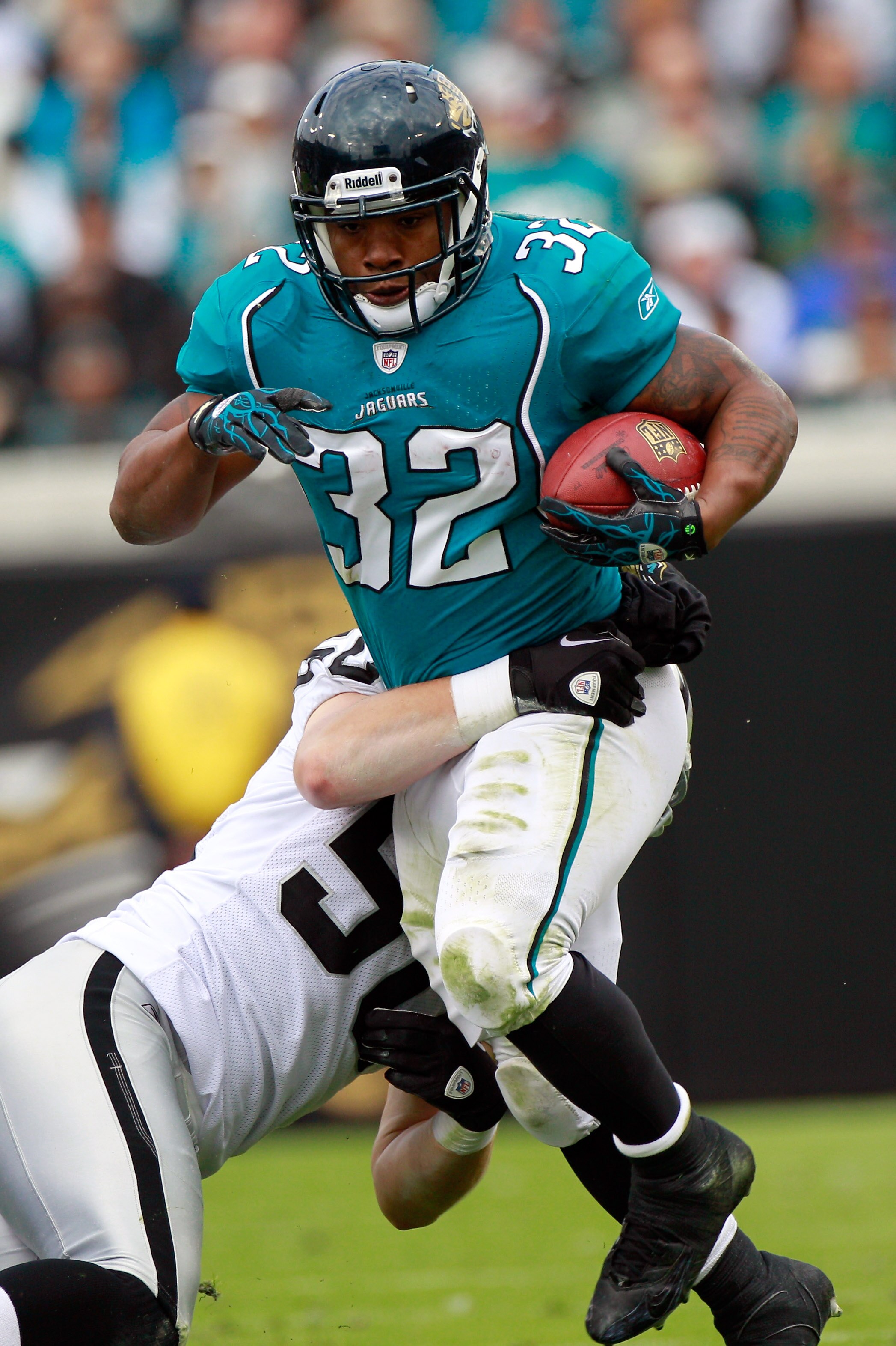 JACKSONVILLE, FL - DECEMBER 12:  Maurice Jones-Drew #32 of the Jacksonville Jaguars breaks the tackle of Travis Goethel #50 of the Oakland Raiders during the game at EverBank Field on December 12, 2010 in Jacksonville, Florida.  (Photo by Sam Greenwood/Ge