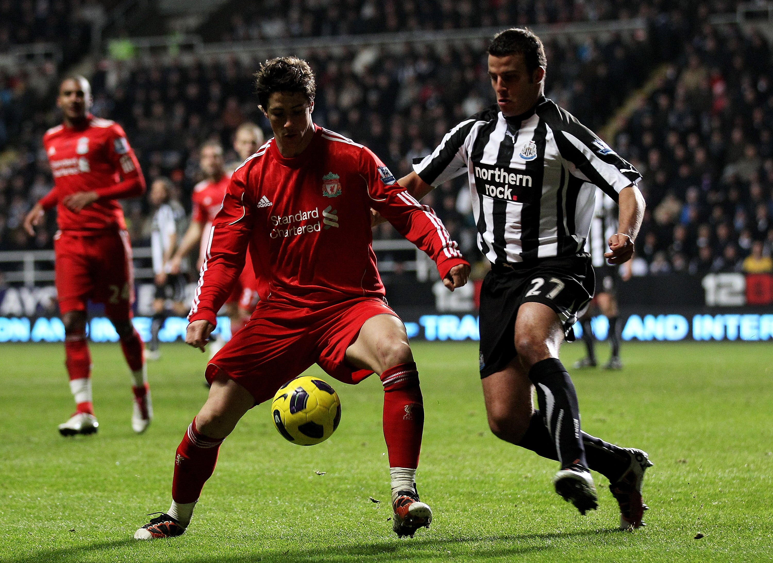 NEWCASTLE UPON TYNE, ENGLAND - DECEMBER 11:  Fernando Torres of Liverpool competes for the ball with Steven Taylor of Newcastle United during the Barclays Premier League match between Newcastle United and Liverpool at St James' Park on December 11, 2010 i