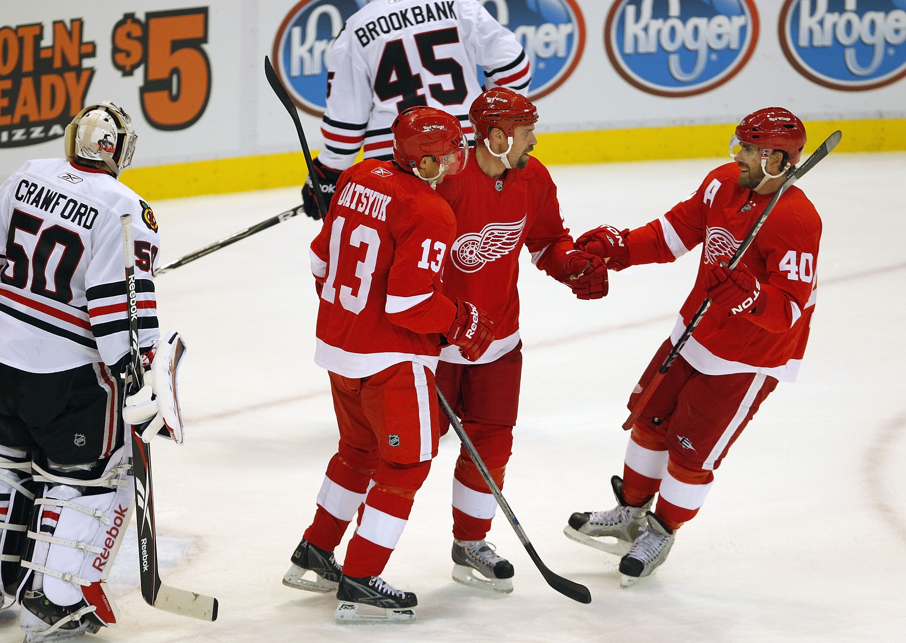 DETROIT - SEPTEMBER 24: Tomas Holmstrom #96 of the Detroit Red Wings celebrates a first period goal with Pavel Datsyuk and Henrik Zetterberg #40 during a pre season game on September 24, 2010 at Joe Louis Arena in Detroit, Michigan.  (Photo by Gregory Sha