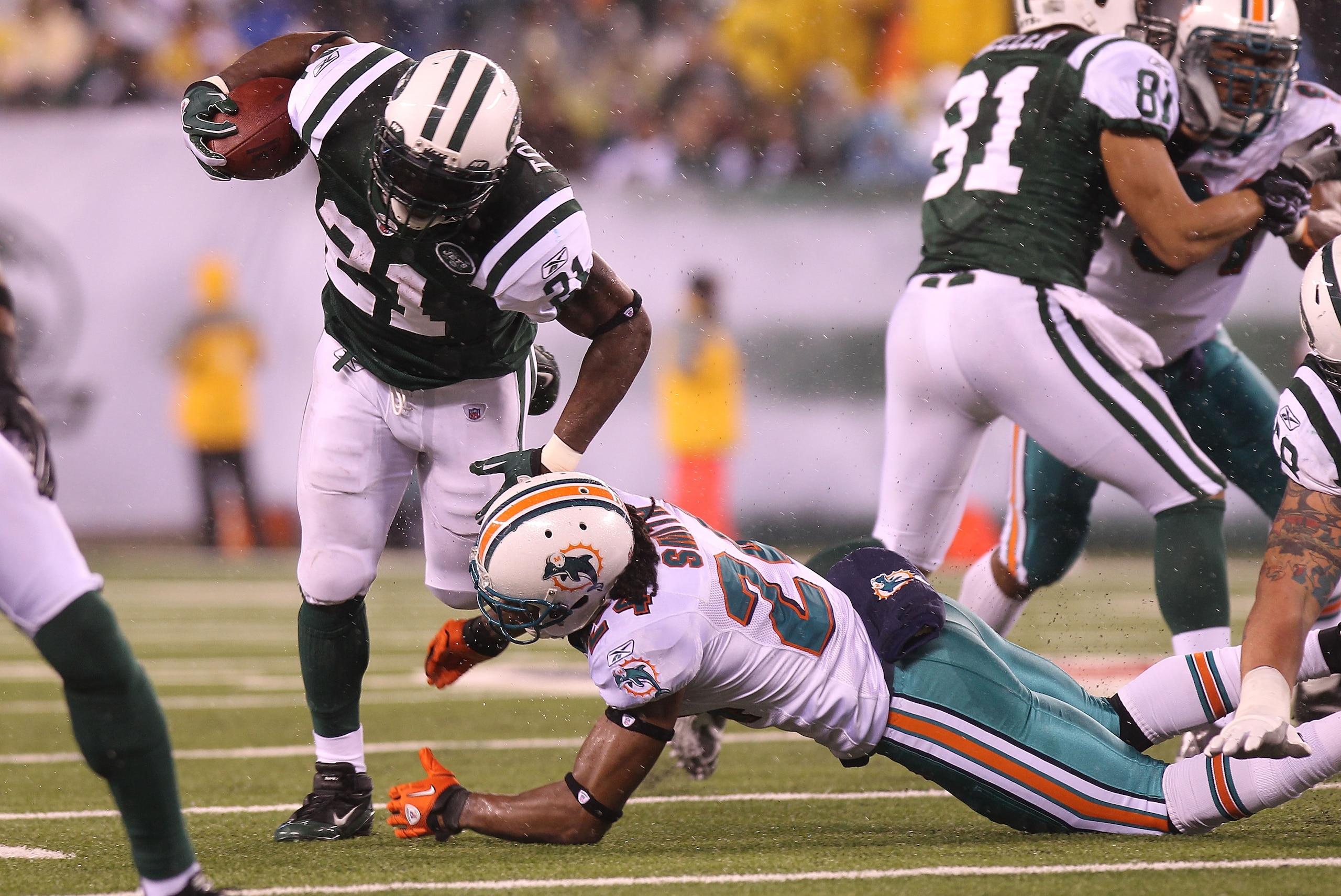 EAST RUTHERFORD, NJ - DECEMBER 12:  LaDainian Tomlinson #21 of the New York Jets is tackled by Sean Smith #24 of the Miami Dolphins at New Meadowlands Stadium on December 12, 2010 in East Rutherford, New Jersey.  (Photo by Nick Laham/Getty Images)