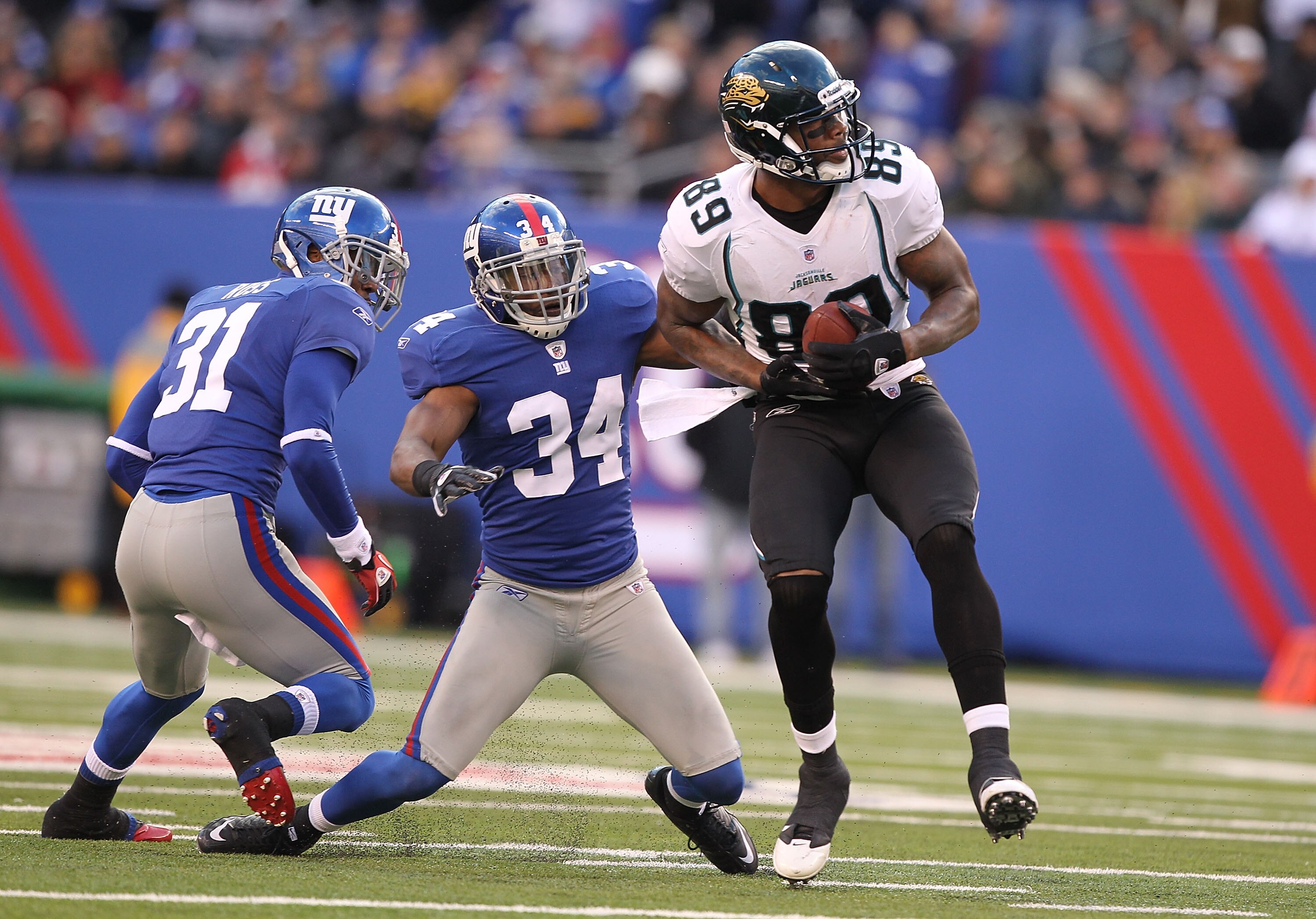 EAST RUTHERFORD, NJ - NOVEMBER 28:  Marcedes Lewis #89  of the Jacksonville Jaguars makes a catch as Deon Grant #34 and Aaron Ross #31 of the New York Giants defend during their game on November 28, 2010 at The New Meadowlands Stadium in East Rutherford,