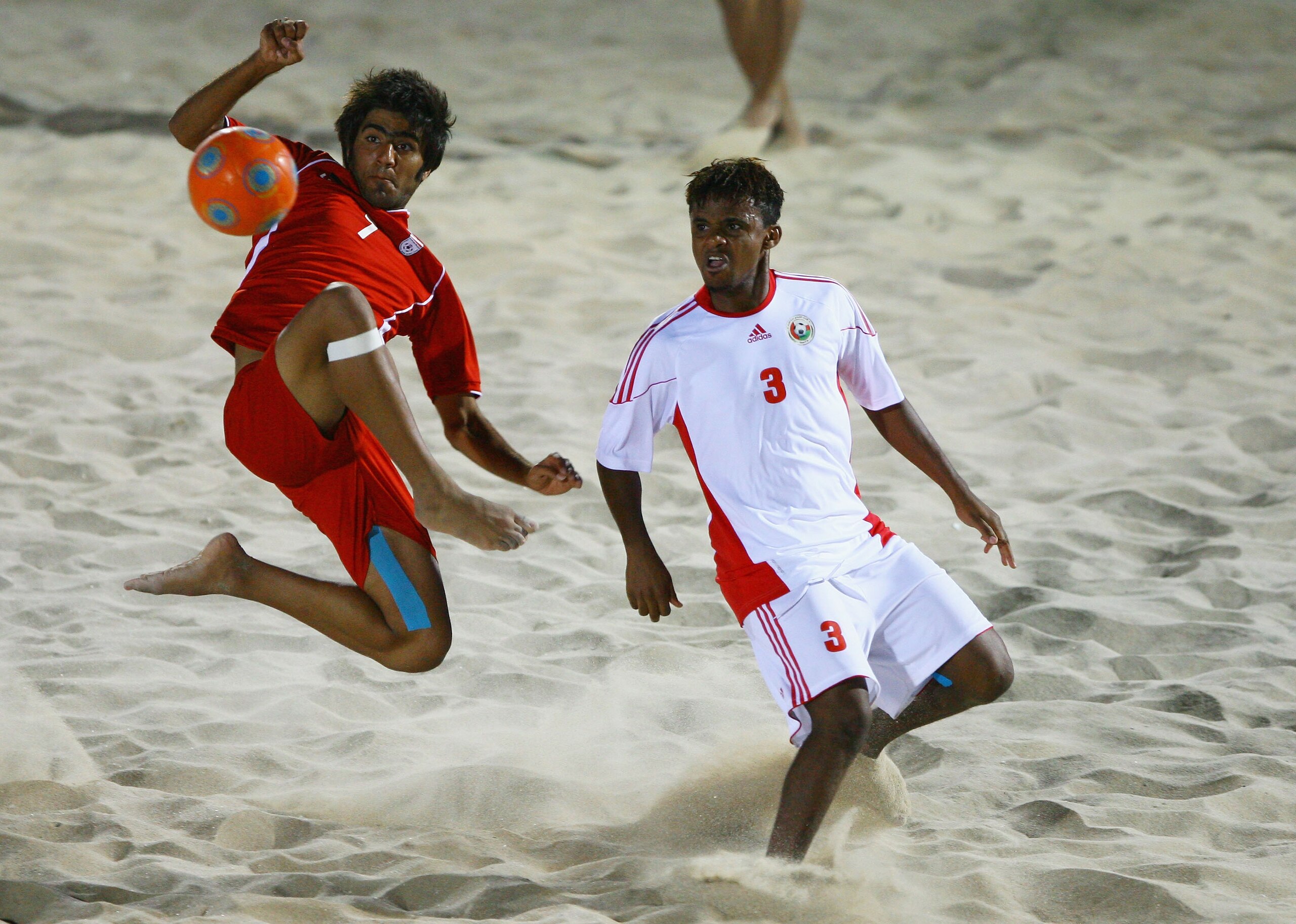 MUSCAT, OMAN - DECEMBER 15: Mehran Morshedizadeh of Iran fights for the ball with Jalal Al Sinani of Oman in the Beach Soccer Semi Final between Oman and Iran at Al-Musannah Sports City during day eight of the 2nd Asian Beach Games Muscat 2010 on Decemb MUSCAT, OMAN - DECEMBER 15: Mehran Morshedizadeh of Iran fights for the ball with Jalal Al Sinani of Oman in the Beach Soccer Semi Final between Oman and Iran at Al-Musannah Sports City during day eight of the 2nd Asian Beach Games Muscat 2010 on Decemb