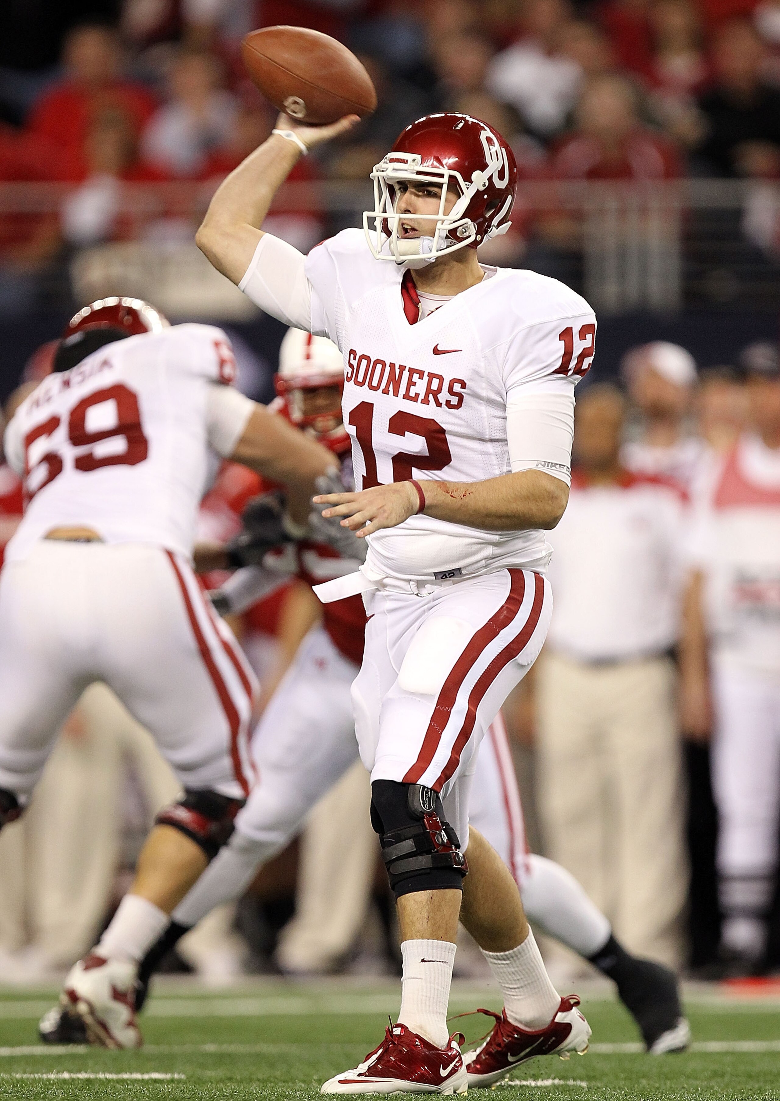 ARLINGTON, TX - DECEMBER 04:  Quarterback Landry Jones #12 of the Oklahoma Sooners drops back to pass against the Nebraska Cornhuskers during the Big 12 Championship at Cowboys Stadium on December 4, 2010 in Arlington, Texas.  (Photo by Ronald Martinez/Ge