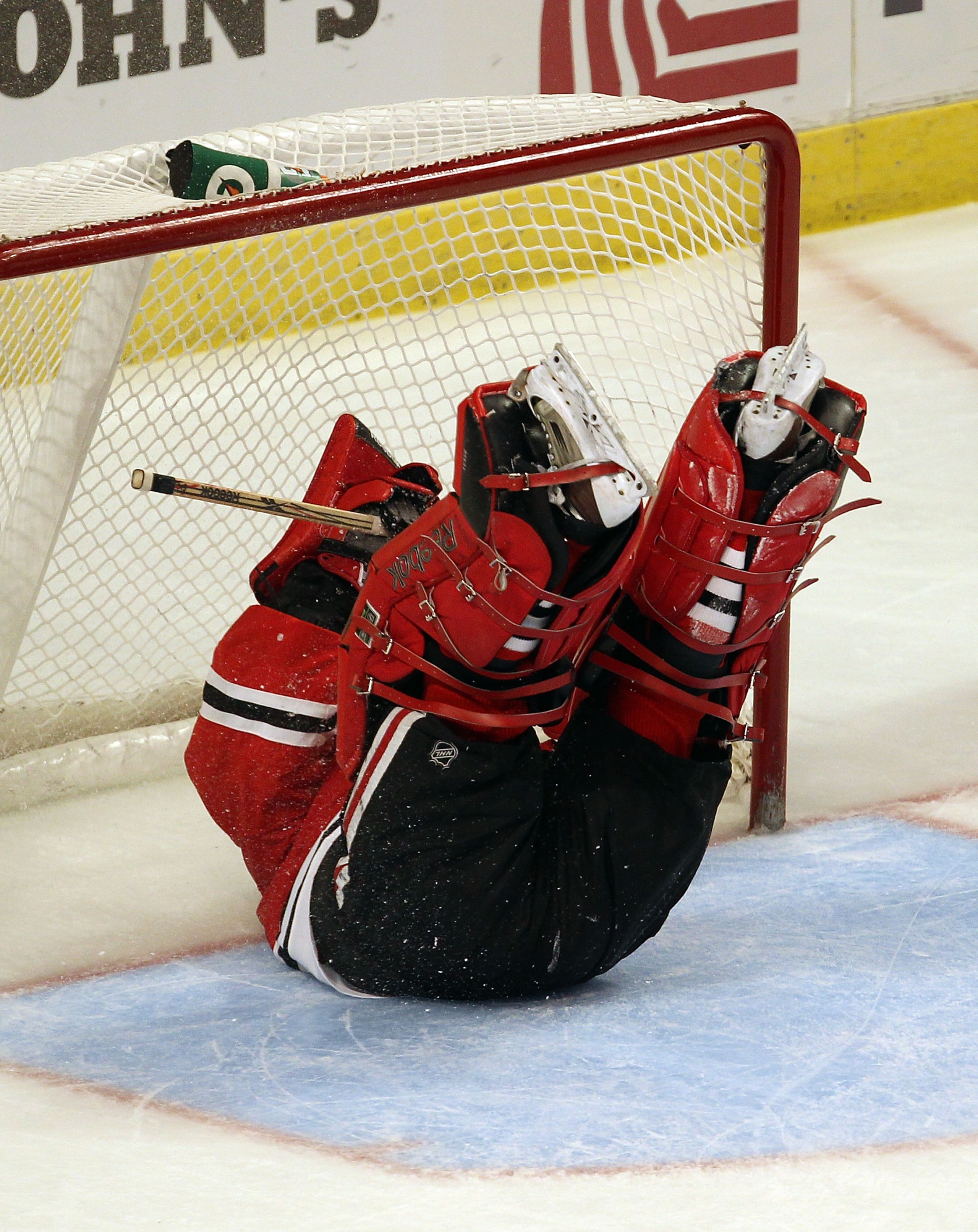 CHICAGO - DECEMBER 03: Marty Turco #30 of the Chicago Blackhawks ends up on his back after Henrik Sedin of the Vancouver Canucks scored a 3rd period goal at the United Center on December 3, 2010 in Chicago, Illinois. The Canucks defeated the Blackhawks 3-