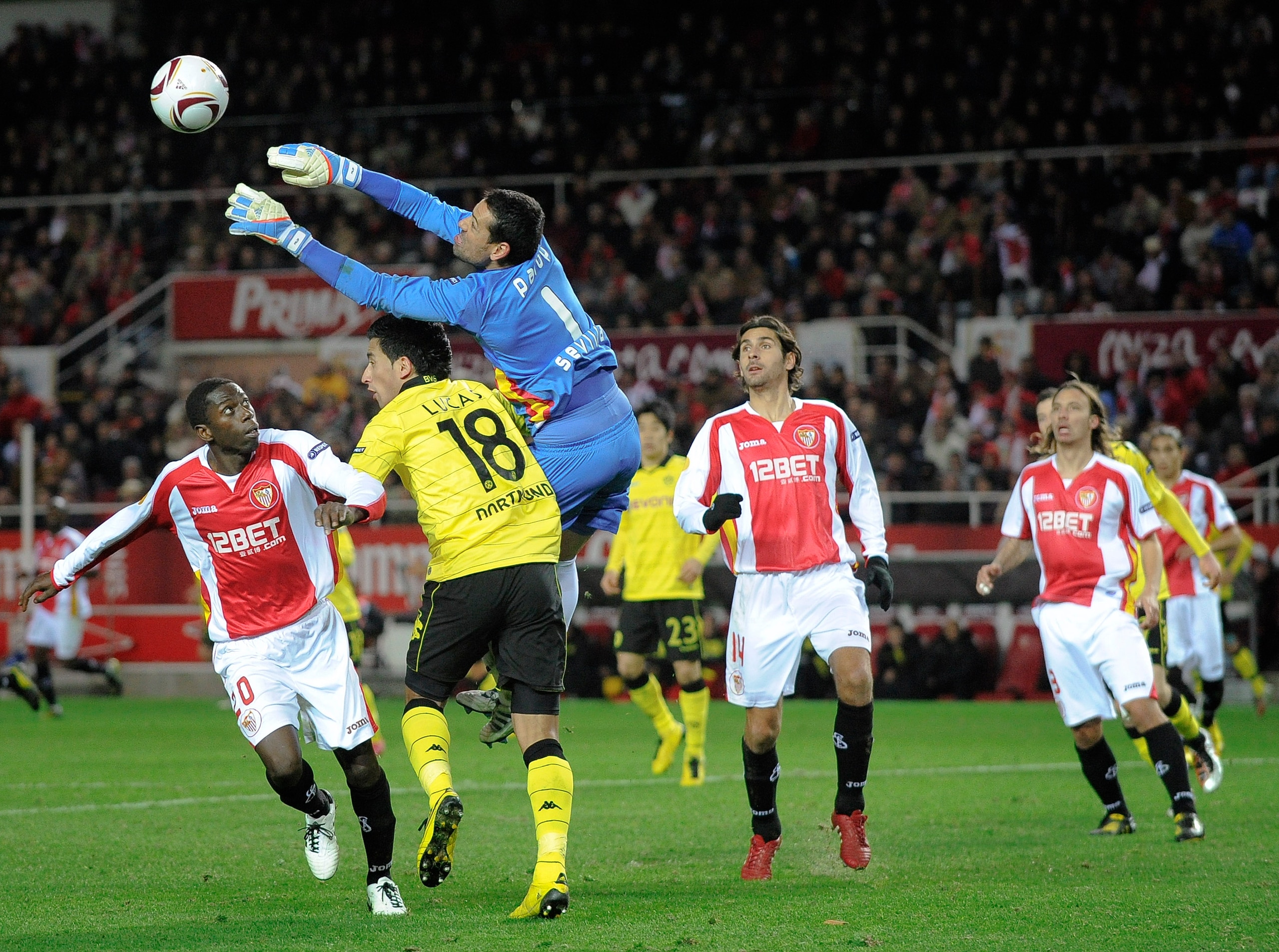 SEVILLE, SPAIN - DECEMBER 15: Lucas Barrios of Borussia Dortmund (2ndL) and Andres Palop of Sevilla FC (C) duel for a high ball during the UEFA Europa League group J match between Sevilla and Borussia Dortmund at Estadio Ramon Sanchez Pizjuan on December SEVILLE, SPAIN - DECEMBER 15: Lucas Barrios of Borussia Dortmund (2ndL) and Andres Palop of Sevilla FC (C) duel for a high ball during the UEFA Europa League group J match between Sevilla and Borussia Dortmund at Estadio Ramon Sanchez Pizjuan on December