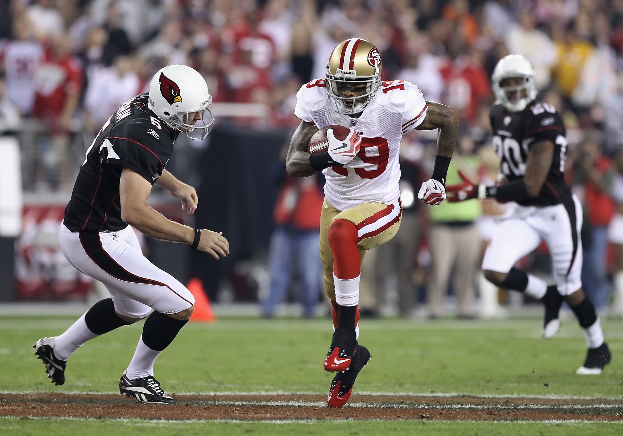 GLENDALE, AZ - NOVEMBER 29:  Wide receiver Ted Ginn Jr. #19 of the San Francisco 49ers runs with the football past Ben Graham #5 of the Arizona Cardinals during the NFL game at the University of Phoenix Stadium on November 29, 2010 in Glendale, Arizona. T