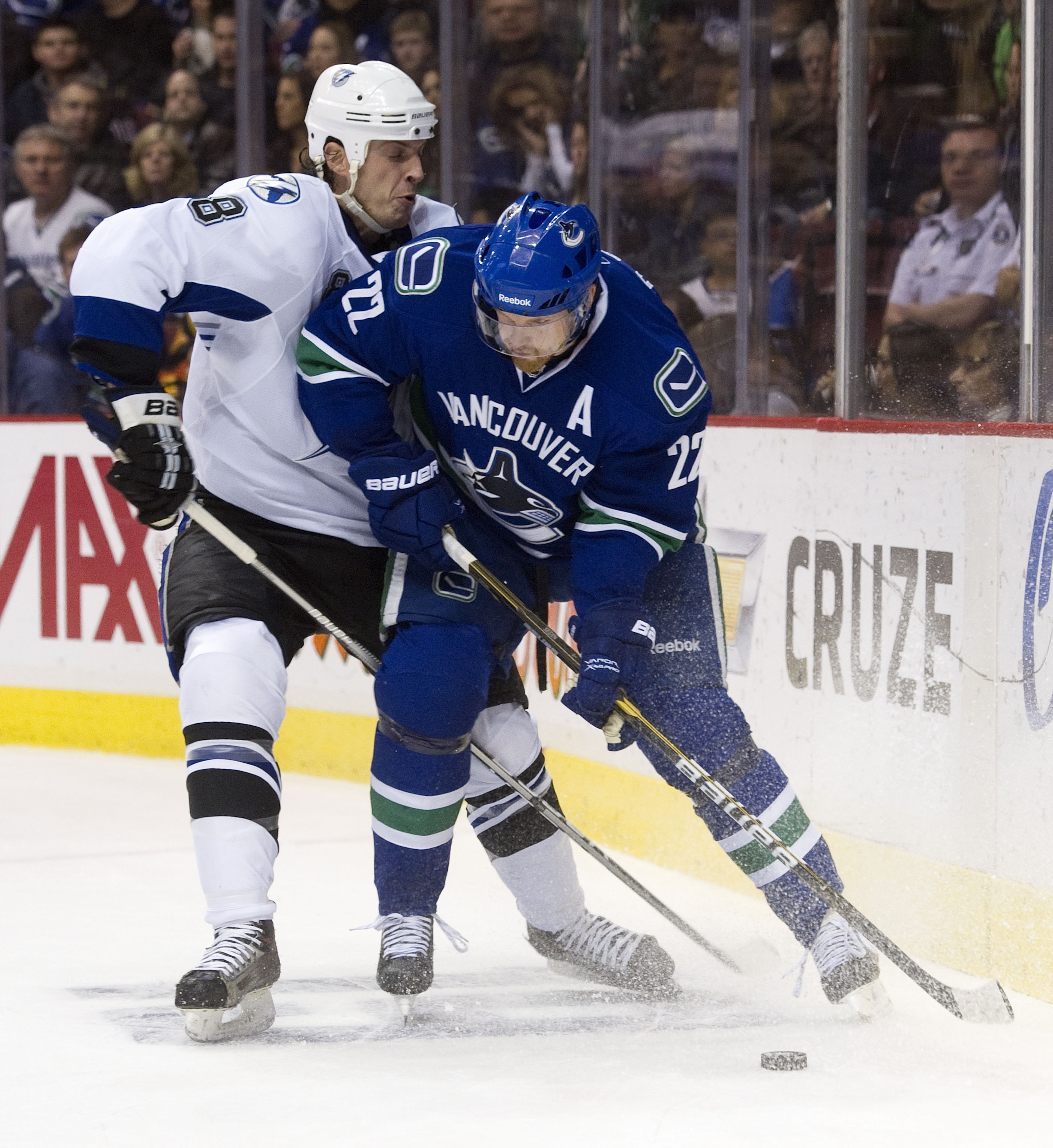 VANCOUVER, CANADA - DECEMBER 11: Daniel Sedin #22 of the Vancouver Canucks tries to fight off Randy Jones #8 of the Tampa Bay Lightning during the second period in NHL action on December 11, 2010 at Rogers Arena in Vancouver, BC, Canada.  (Photo by Rich L