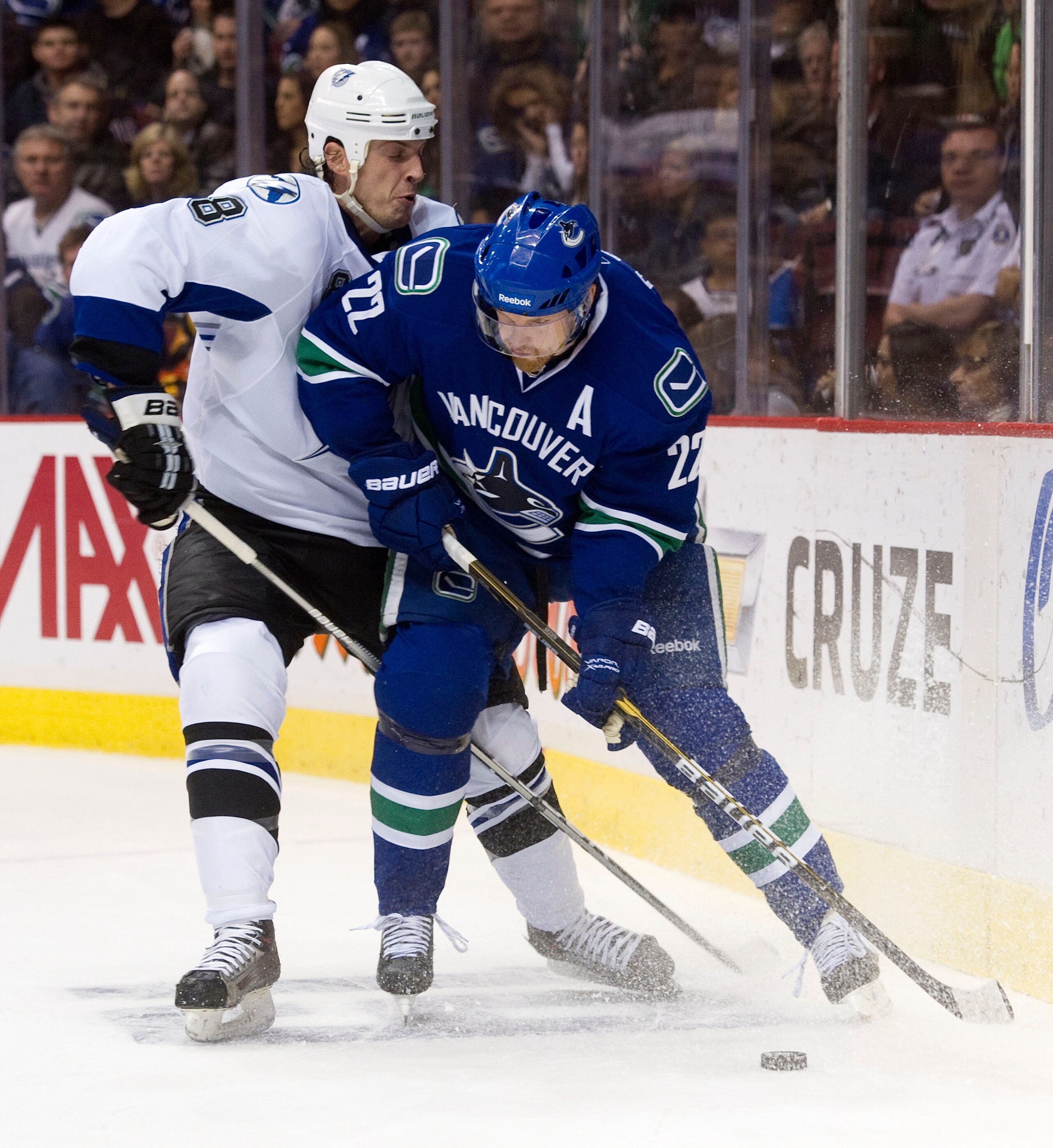 VANCOUVER, CANADA - DECEMBER 11: Daniel Sedin #22 of the Vancouver Canucks tries to fight off Randy Jones #8 of the Tampa Bay Lightning during the second period in NHL action on December 11, 2010 at Rogers Arena in Vancouver, BC, Canada.  (Photo by Rich L