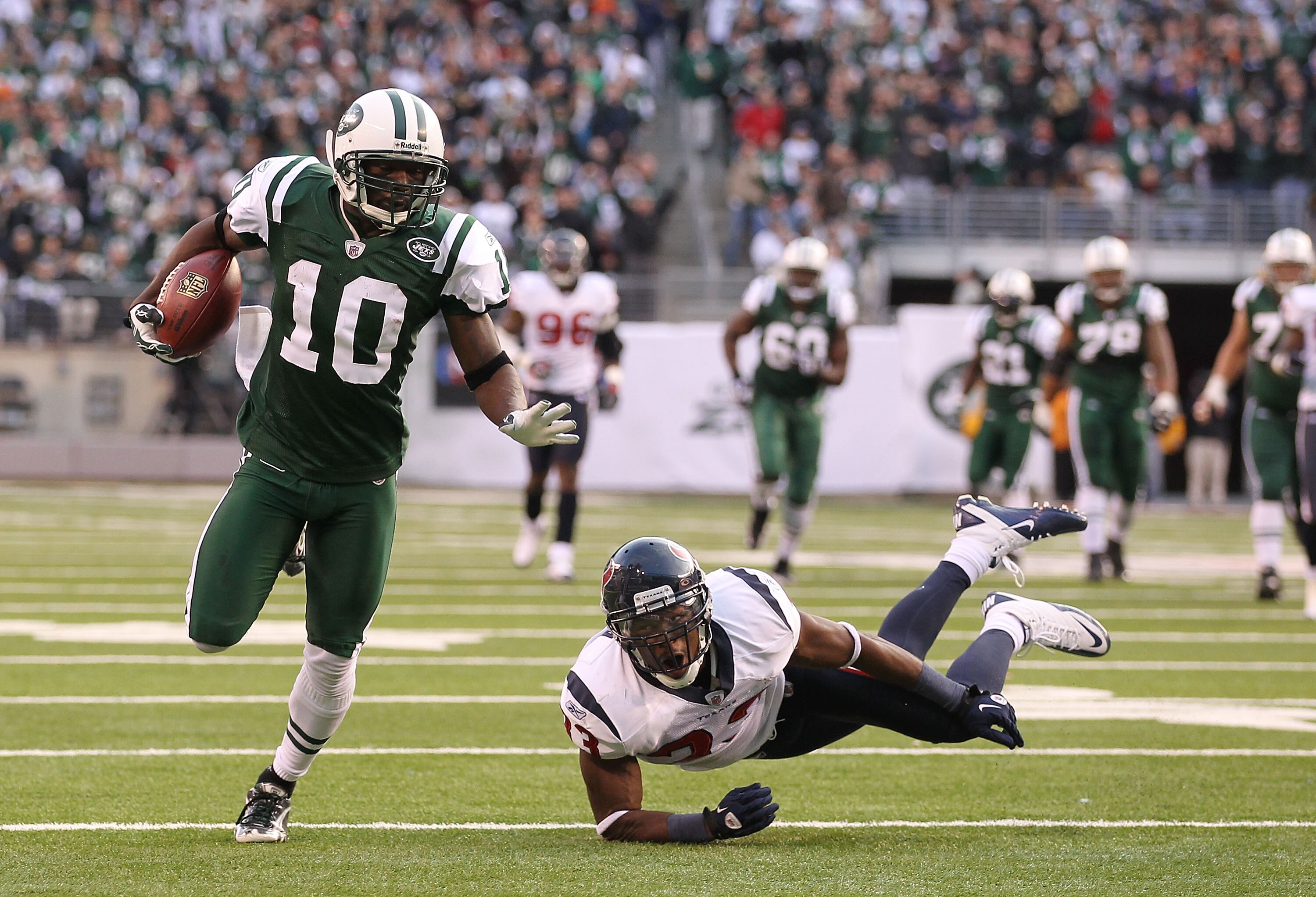 EAST RUTHERFORD, NJ - NOVEMBER 21:  Santonio Holmes #10 of the New York Jets eludes Troy Nolan #33 of the Houston Texans to score a touchdown during the third quarter of their  game on November 21, 2010 at the New Meadowlands Stadium in East Rutherford, N