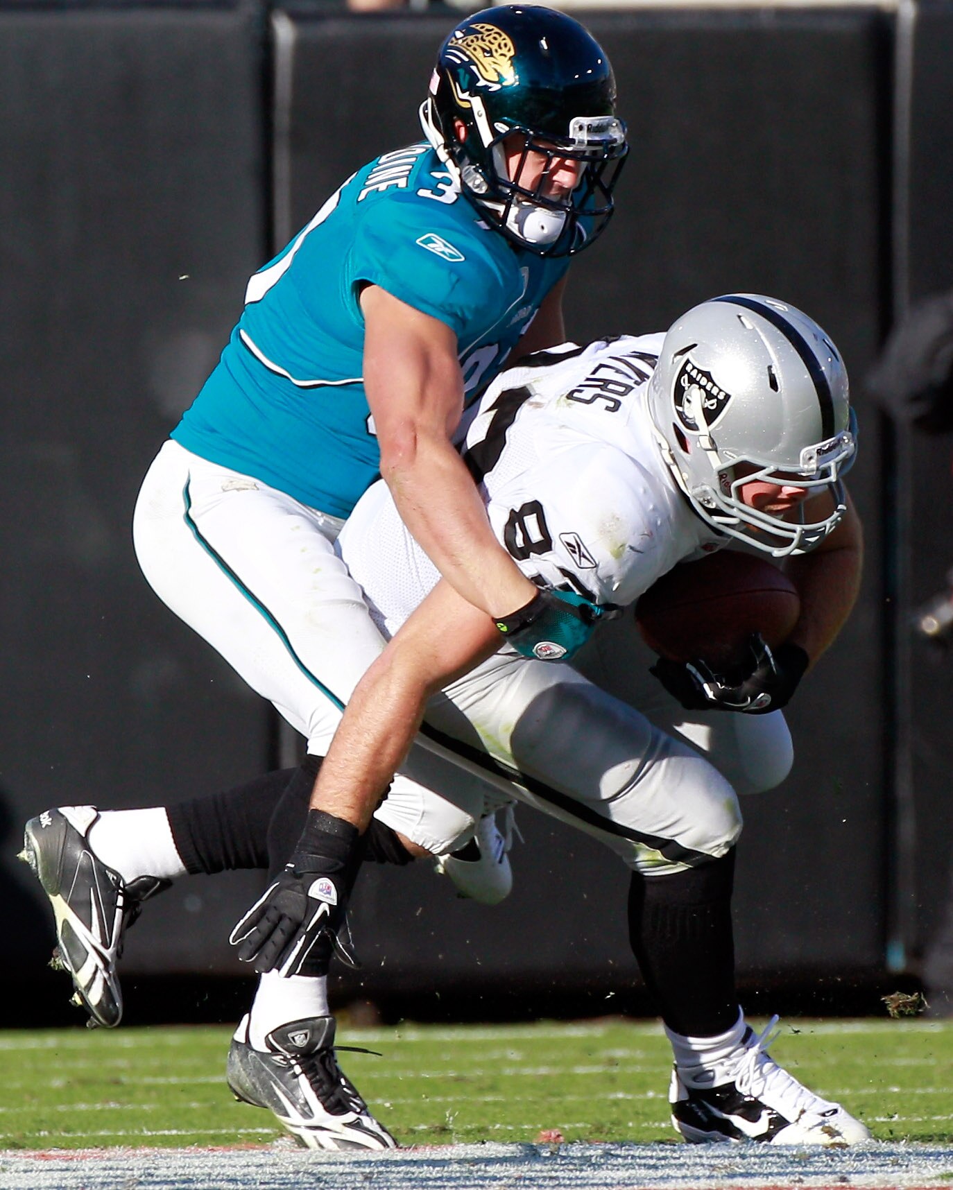 JACKSONVILLE, FL - DECEMBER 12:  Sean Considine #37 of the Jacksonville Jaguars tackles Brandon Myers #83 of the Oakland Raiders during the game at EverBank Field on December 12, 2010 in Jacksonville, Florida.  (Photo by Sam Greenwood/Getty Images)