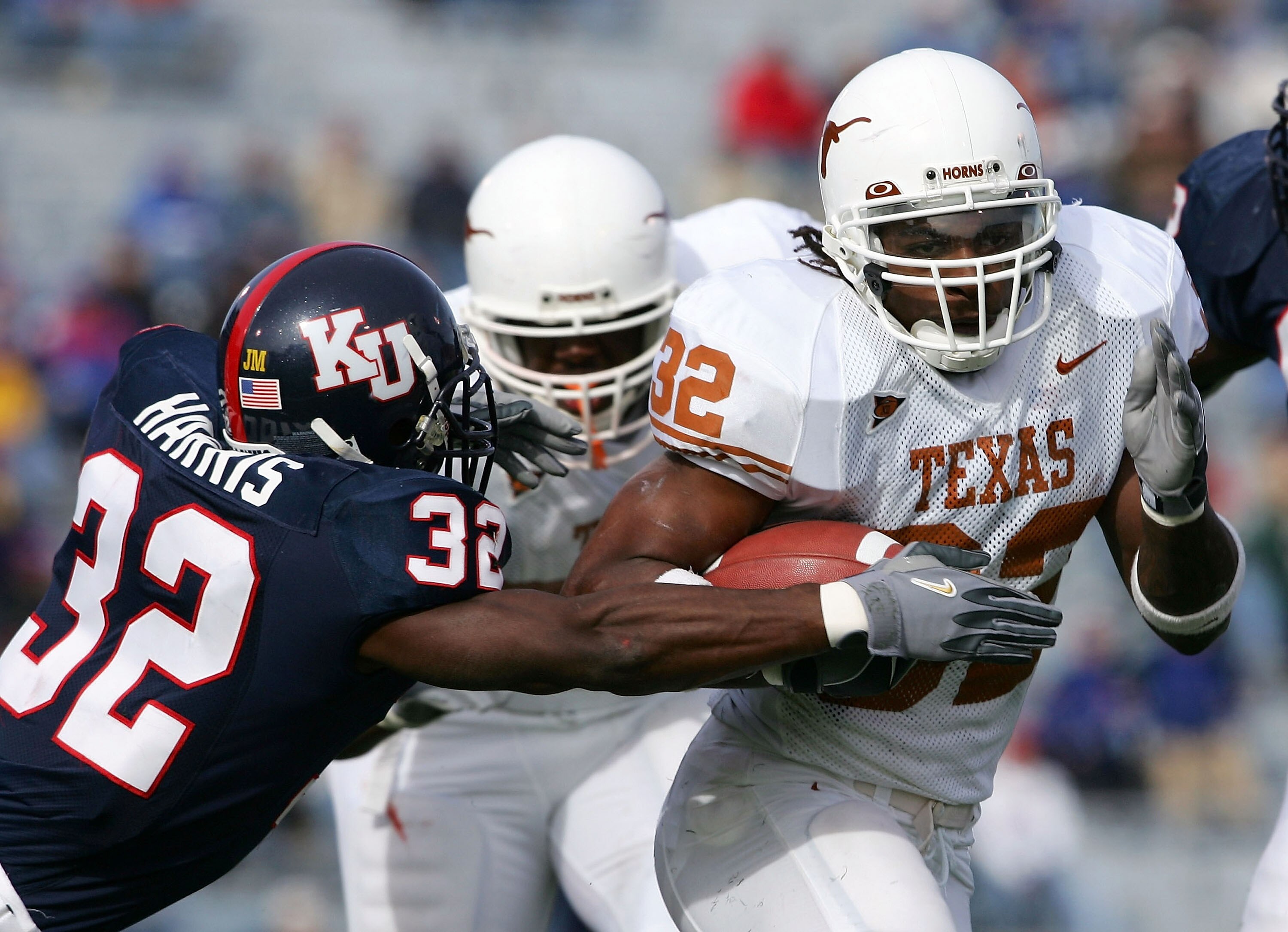 LAWRENCE, KS - NOVEMBER 13:  Cedric Benson #32 of the Texas Longhorns breaks free from Rodney Harris #32 of the Kansas Jayhawks to score a touchdown in the second quarter on November 13, 2004 at Memorial Stadium in Lawrence, Kansas.  (Photo by Elsa/Getty
