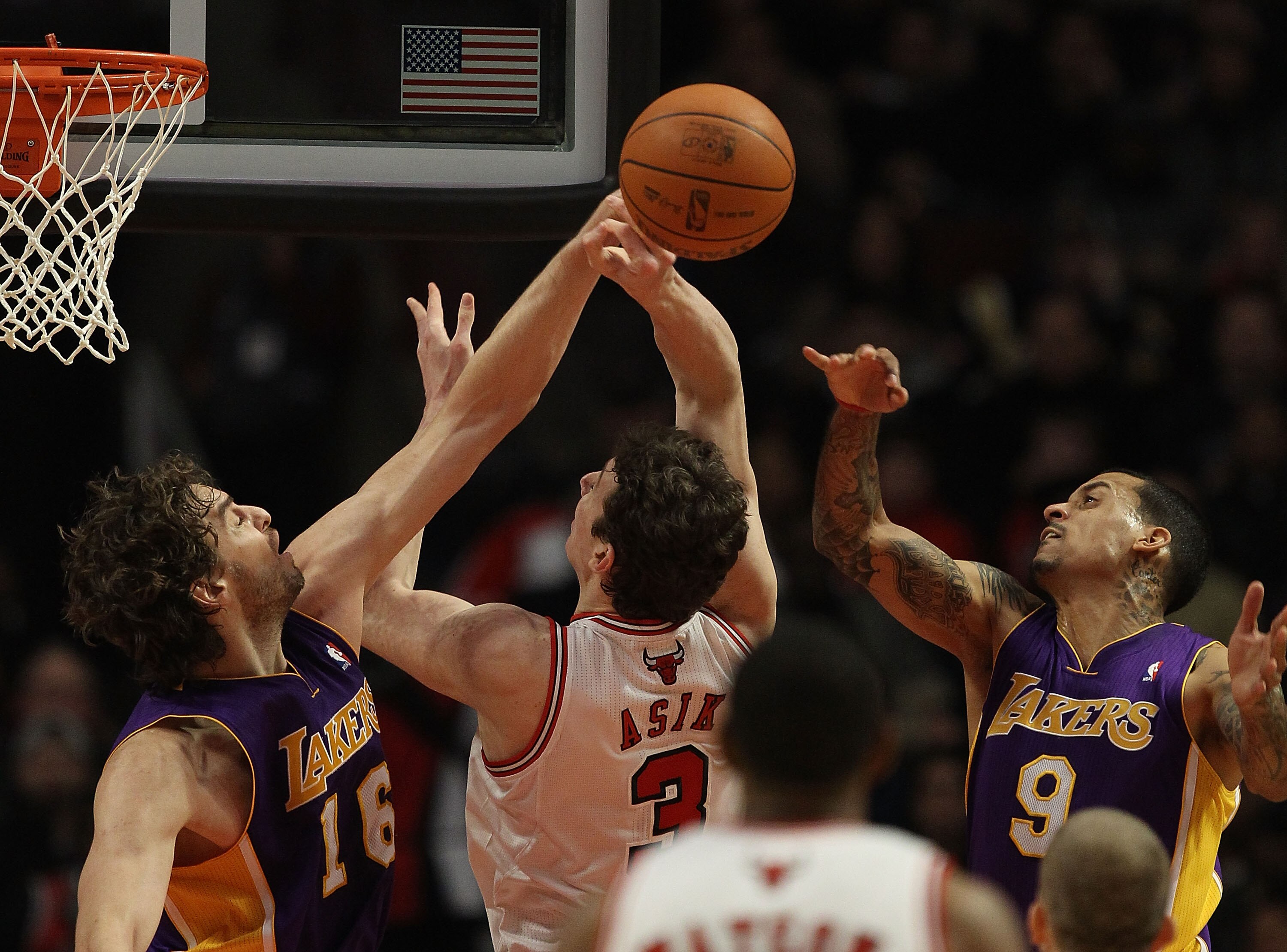 CHICAGO, IL - DECEMBER 10: Pau Gasol #16 of the Los Angeles Lakers knocks the ball away from Omer Asik #3 of the Chicago Bulls as Matt Barnes #9 defends at the United Center on December 10, 2010 in Chicago, Illinois. The Bulls defeated the Lakers 88-84. N