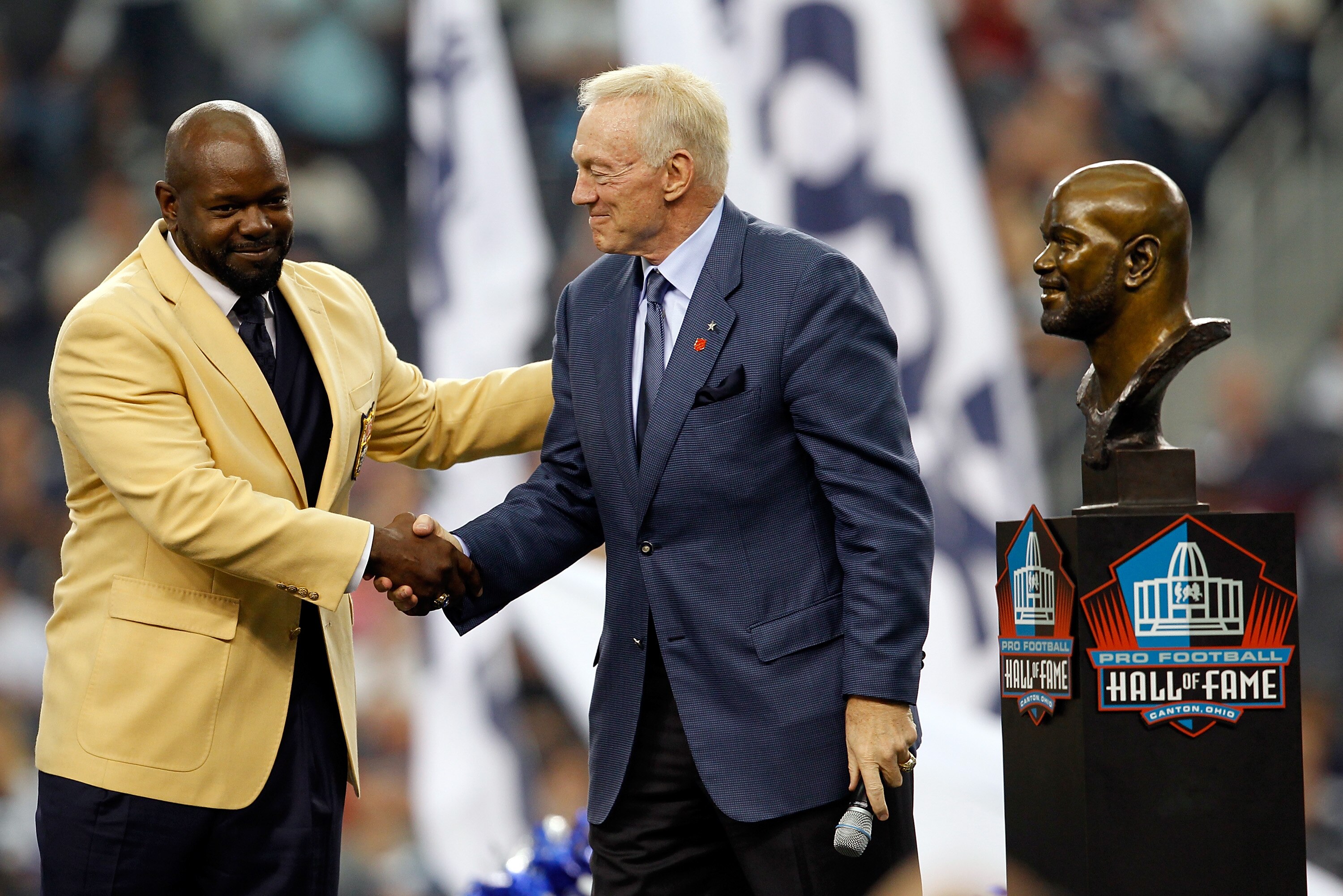 ARLINGTON, TX - NOVEMBER 21:  Dallas Cowboys owner Jerry Jones (R) shakes hands with former Coaboys running back Emmitt Smith as Smith receives his Hall of Fame ring during a halftime ceremony at Cowboys Stadium on November 21, 2010 in Arlington, Texas.