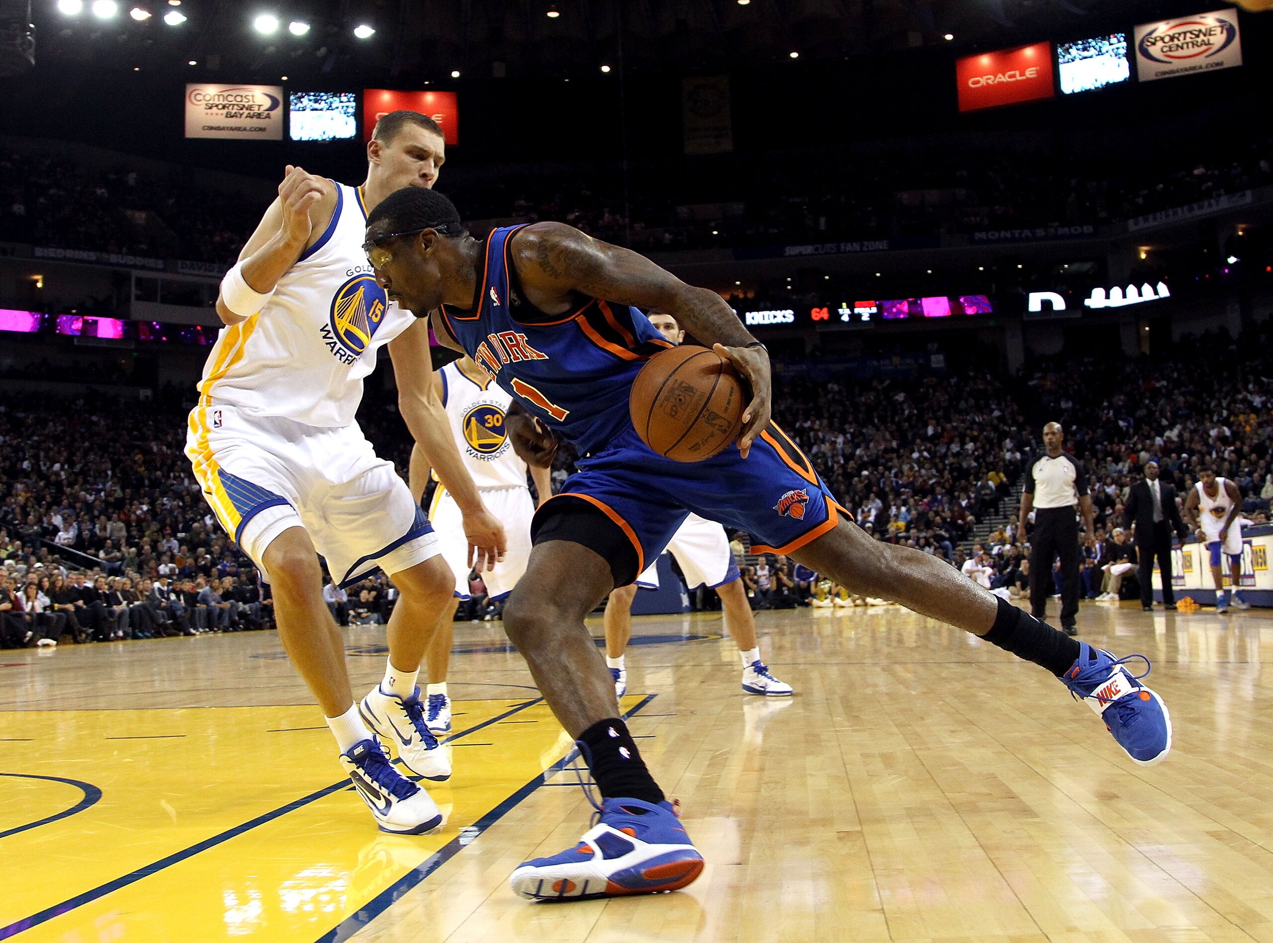 OAKLAND, CA - NOVEMBER 19:  Amar'e Stoudemire #1 of the New York Knicks dribbles past Andris Biedrins #15 of the Golden State Warriors at Oracle Arena on November 19, 2010 in Oakland, California. NOTE TO USER: User expressly acknowledges and agrees that,