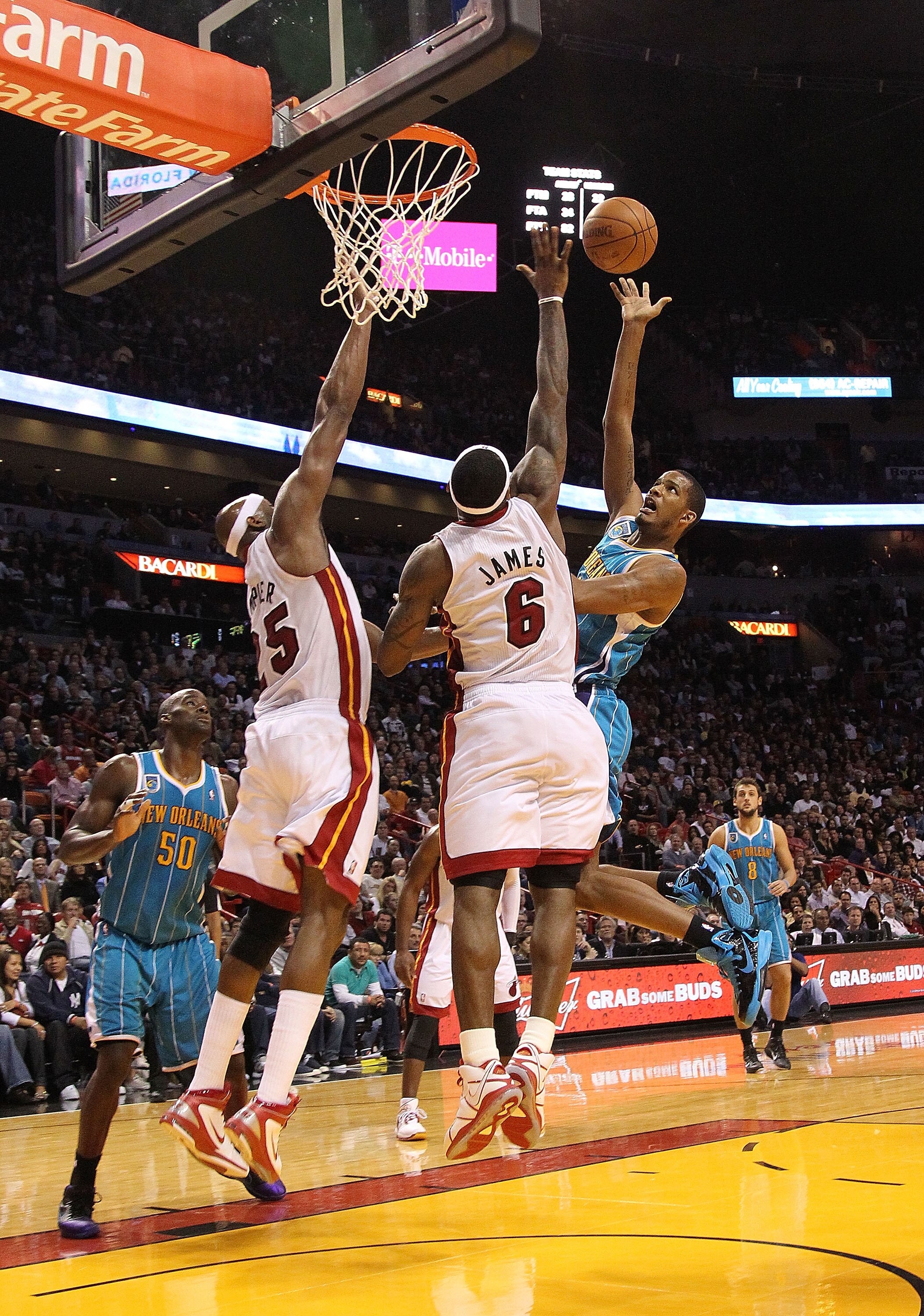 MIAMI, FL - DECEMBER 13:  Trevor Ariza #1 of the New Orleans Hornets shoots over LeBron James #6 and Erick Dampier #25 of the Miami Heat during a foul shot during a game at American Airlines Arena on December 13, 2010 in Miami, Florida. NOTE TO USER: User
