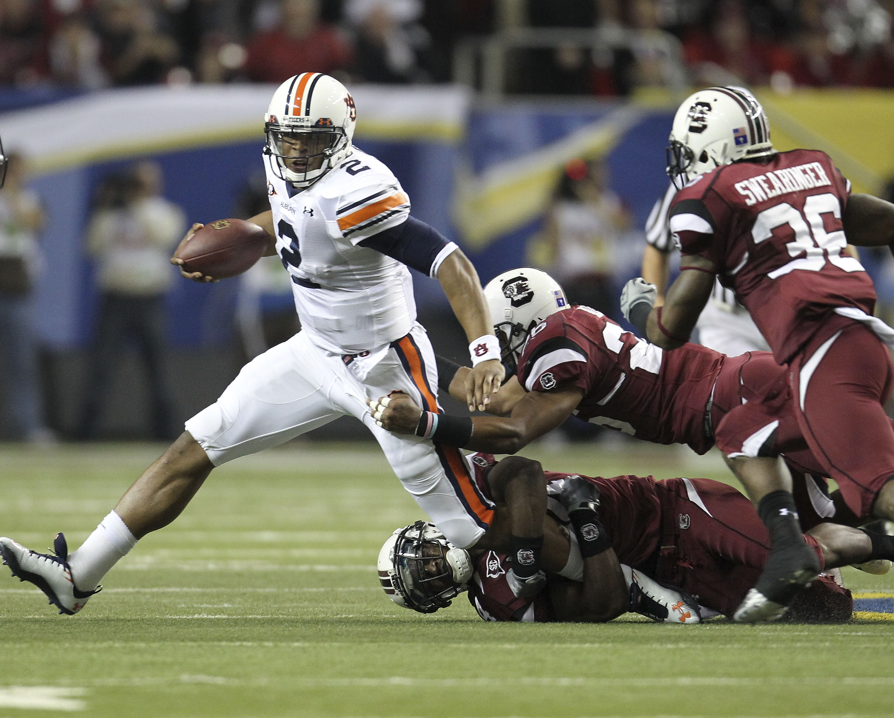 ATLANTA - DECEMBER 4:  Quarterback Cam Newton #2 of the Auburn Tigers is pursued by members of the South Carolina Gamecocks defense during the 2010 SEC Championship against the Auburn Tigers South Carolina Gamecocks at Georgia Dome on December 4, 2010 in