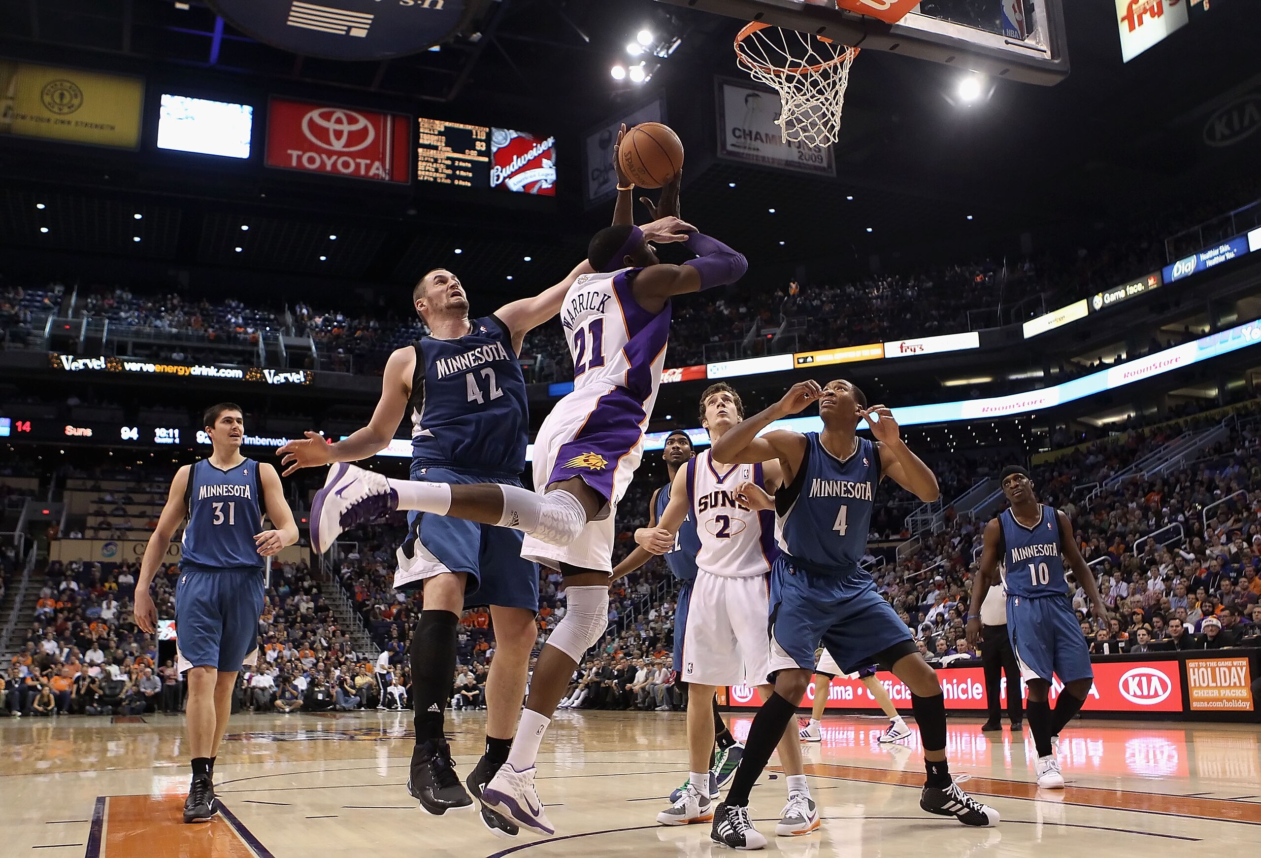 PHOENIX - DECEMBER 15:  Hakim Warrick #21 of the Phoenix Suns is fouled by Kevin Love #42 of the Minnesota Timberwolves as he puts up a shot during the NBA game at US Airways Center on December 15, 2010 in Phoenix, Arizona. The Suns defeated the Timberwol