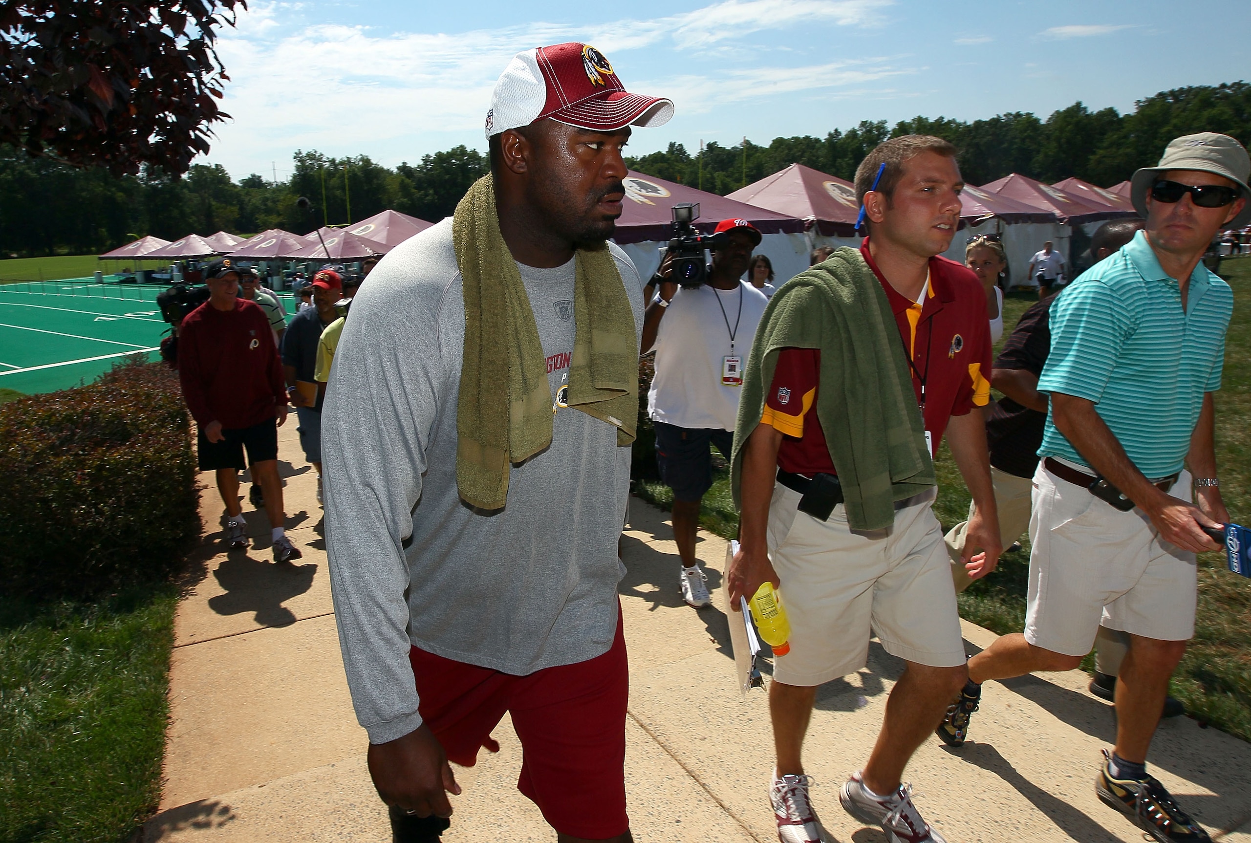ASHBURN, VA - JULY 30:  Defensive lineman Albert Haynesworth #92 (L) returns to the locker room following a workout session with Redskins defensive coordinator Jim Haslett (2nd L) on the second day of training camp July 30, 2010 in Ashburn, Virginia. Hayn