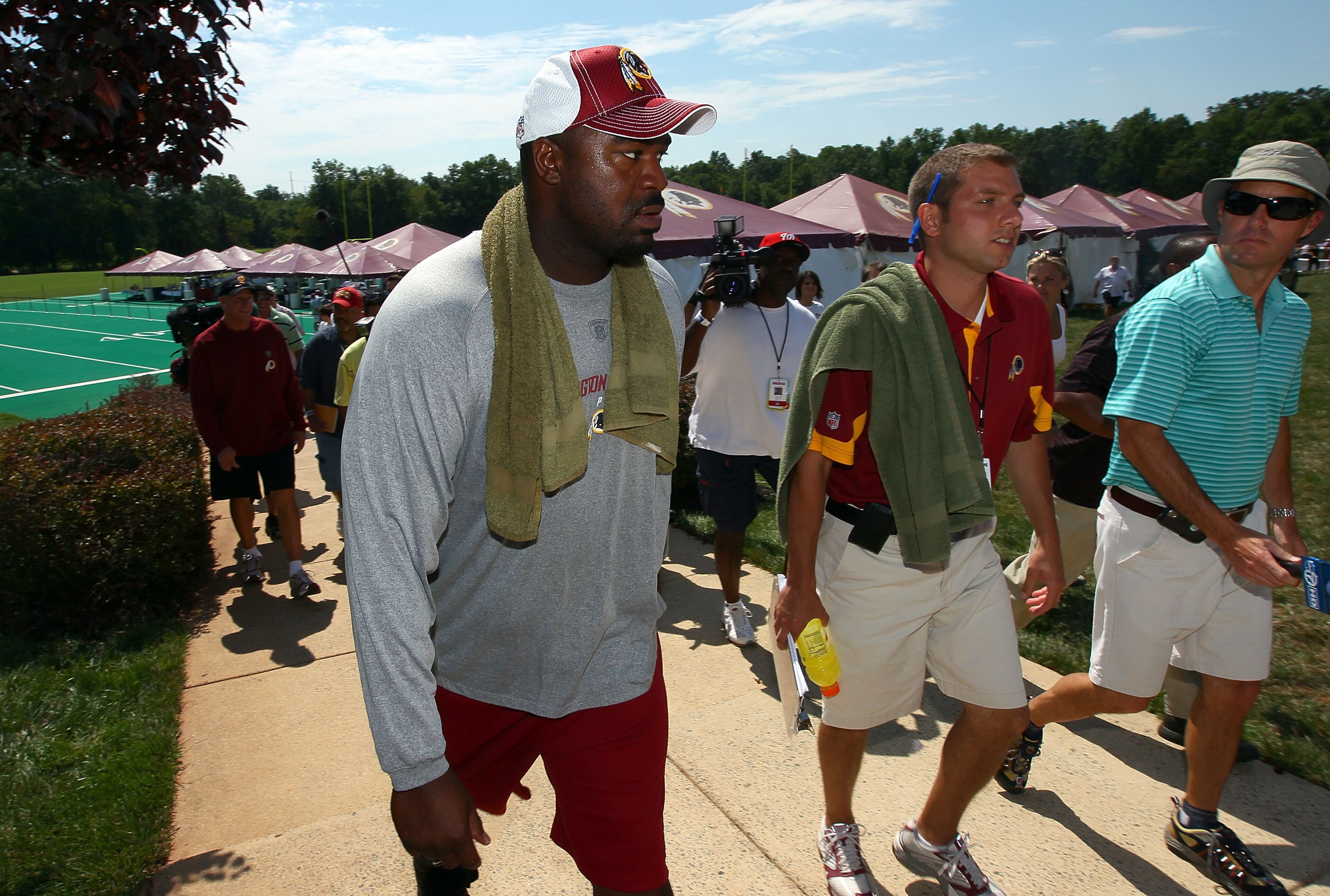 ASHBURN, VA - JULY 30:  Defensive lineman Albert Haynesworth #92 (L) returns to the locker room following a workout session with Redskins defensive coordinator Jim Haslett (2nd L) on the second day of training camp July 30, 2010 in Ashburn, Virginia. Hayn