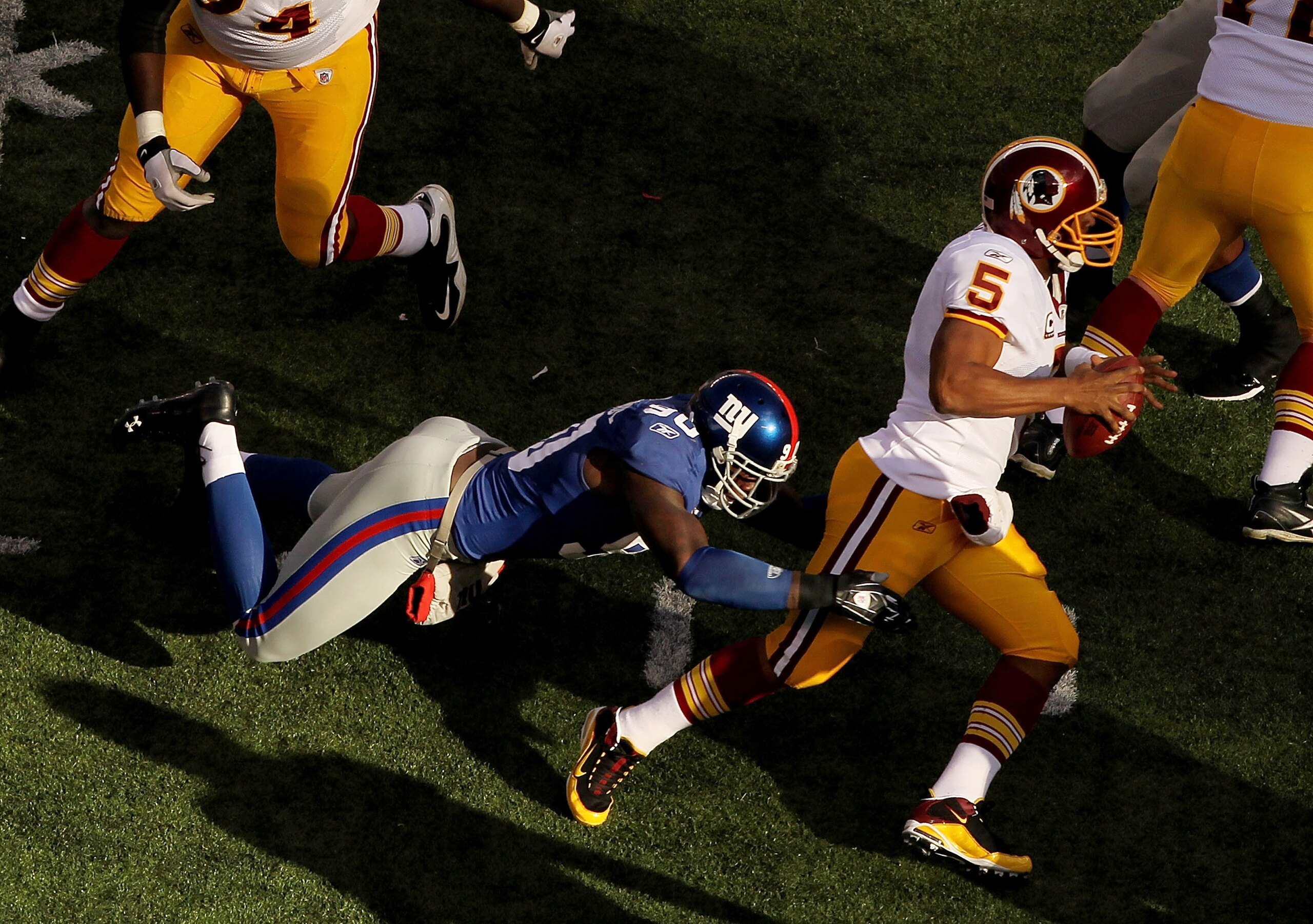 EAST RUTHERFORD, NJ - DECEMBER 05:  Jason Pierre Paul #90 of the New York Giants Sacks Donovan McNabb #5 of the Washington Redskins during their game on December 5, 2010 at The New Meadowlands Stadium in East Rutherford, New Jersey.  (Photo by Al Bello/Ge