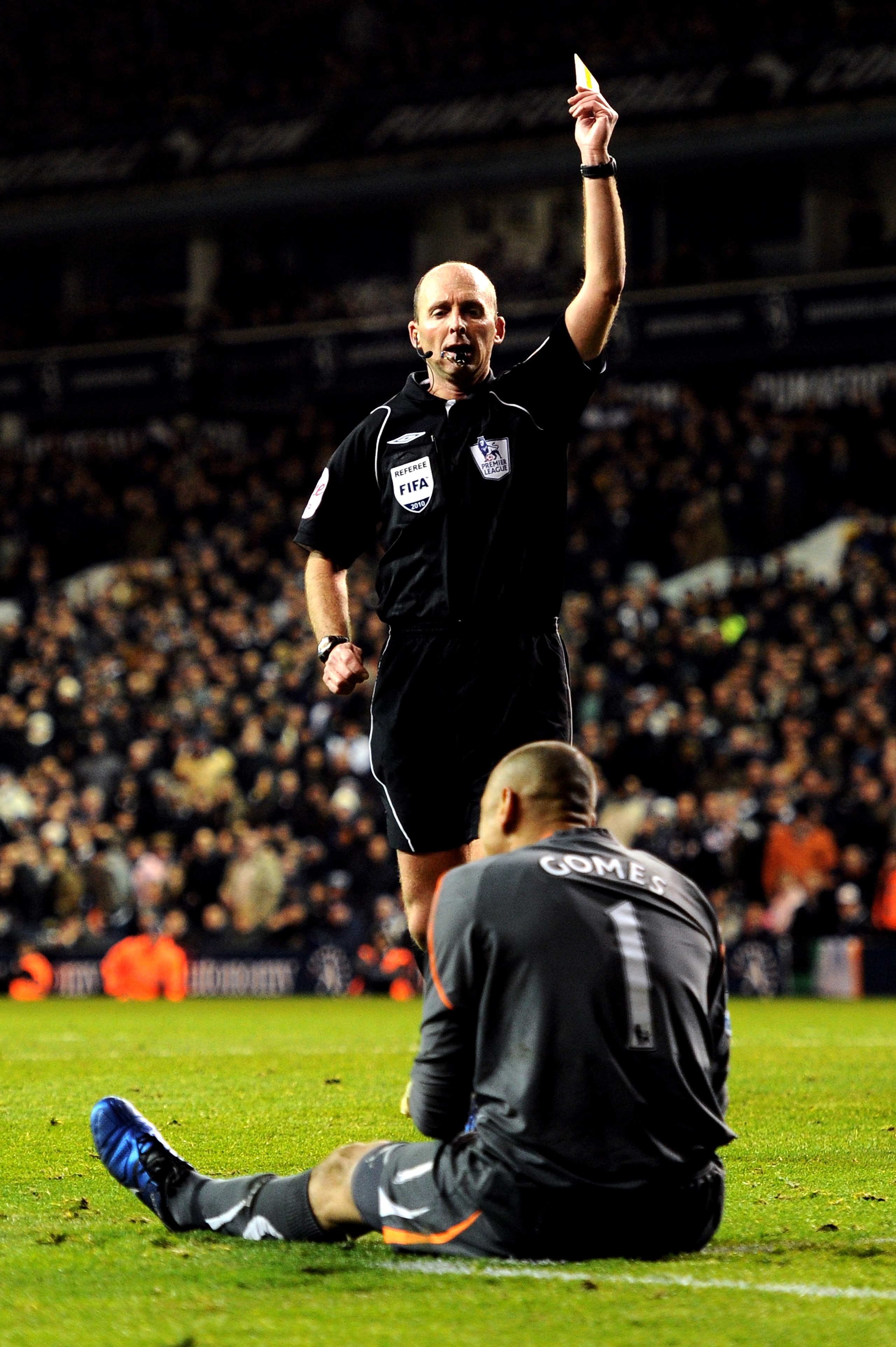 LONDON, ENGLAND - DECEMBER 12: Goalkeeper Heurelho Gomes of Spurs is yellow carded by Referee Mike Dean after colliding with Ramires of Chelsea to concede a late penalty during the Barclays Premier League match between Tottenham Hotspur and Chelsea at Whi