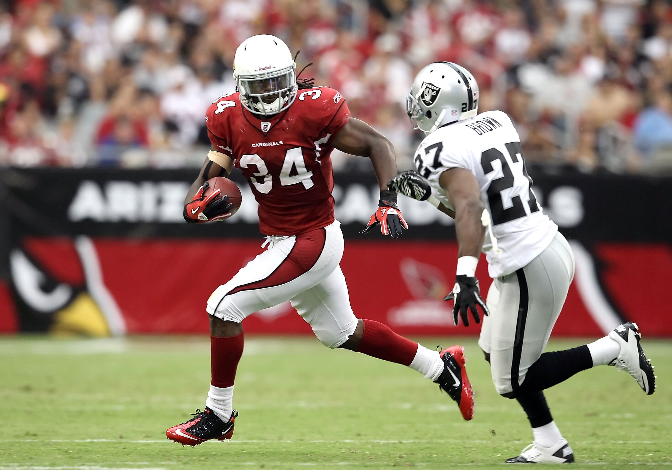 GLENDALE, AZ - SEPTEMBER 26:  Runningback Tim Hightower #34 of the Arizona Cardinals rushes the football against Ricky Brown #27 of the Oakland Raiders during the third quarter of the NFL game at the University of Phoenix Stadium on September 26, 2010 in
