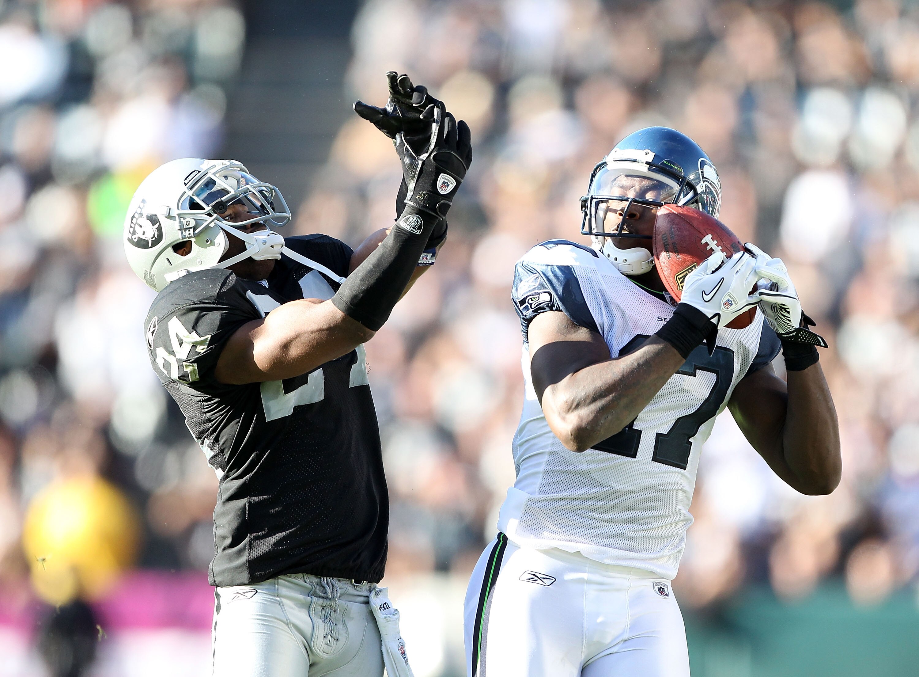 OAKLAND, CA - OCTOBER 31:  Mike Williams #17 of the Seattle Seahawks catches the ball while defended by Michael Huff #24 of the Oakland Raiders at Oakland-Alameda County Coliseum on October 31, 2010 in Oakland, California.  (Photo by Ezra Shaw/Getty Image
