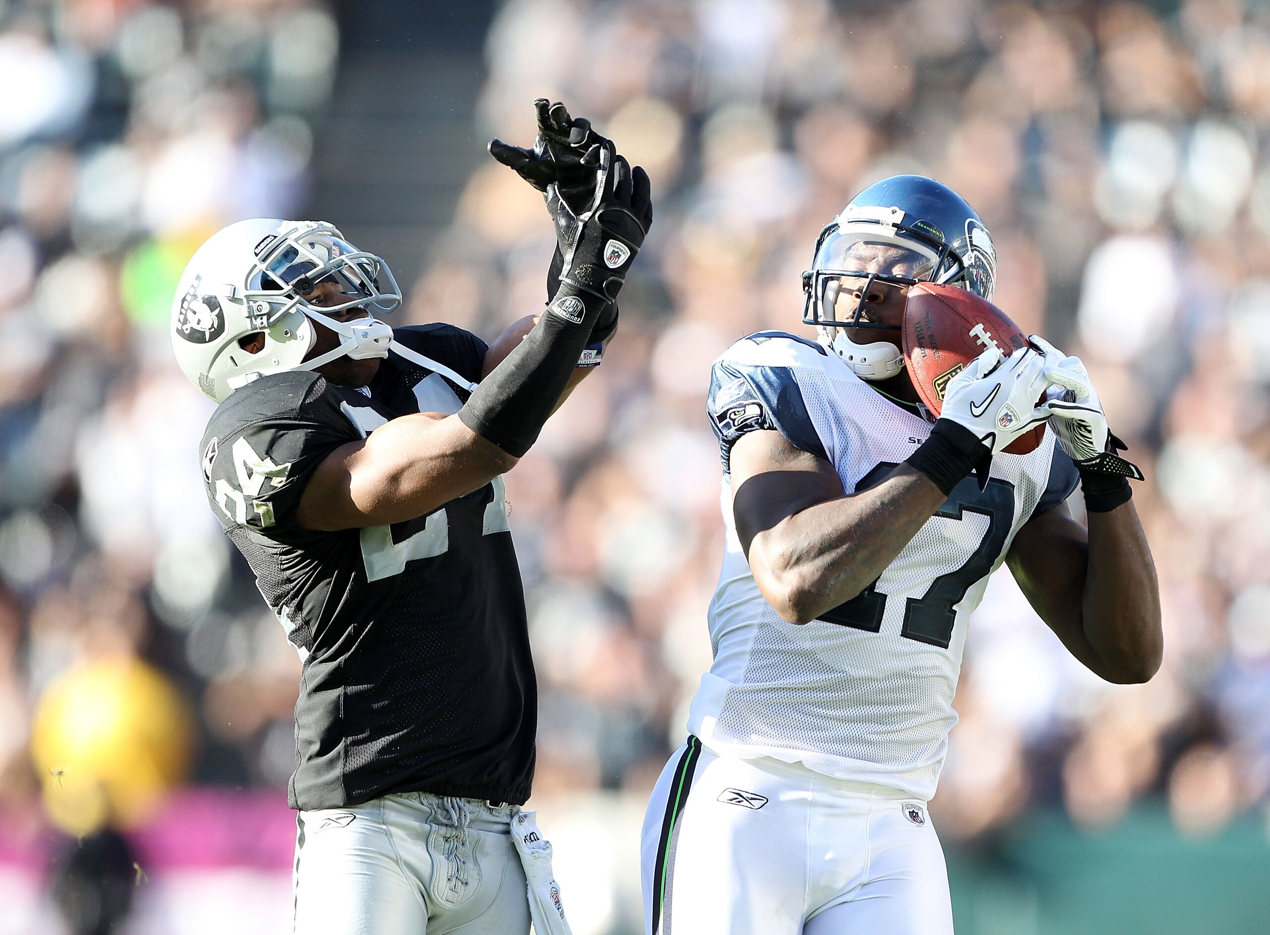 OAKLAND, CA - OCTOBER 31:  Mike Williams #17 of the Seattle Seahawks catches the ball while defended by Michael Huff #24 of the Oakland Raiders at Oakland-Alameda County Coliseum on October 31, 2010 in Oakland, California.  (Photo by Ezra Shaw/Getty Image