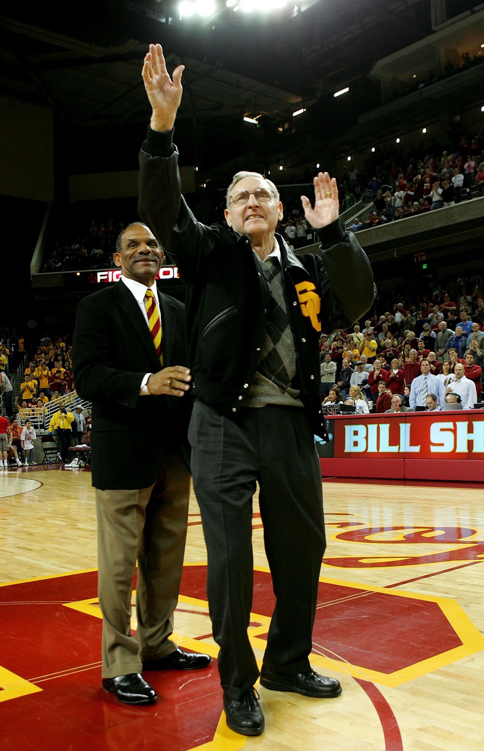 LOS ANGELES - JANUARY 13:  Former USC basketball player and  Basketball Hall of Fame NBA player and coach Bill Sharman (R) waves to the crowd after being presented with a USC letter jacket by USC Trojans athletic director Mike Garrett during ceremonies to