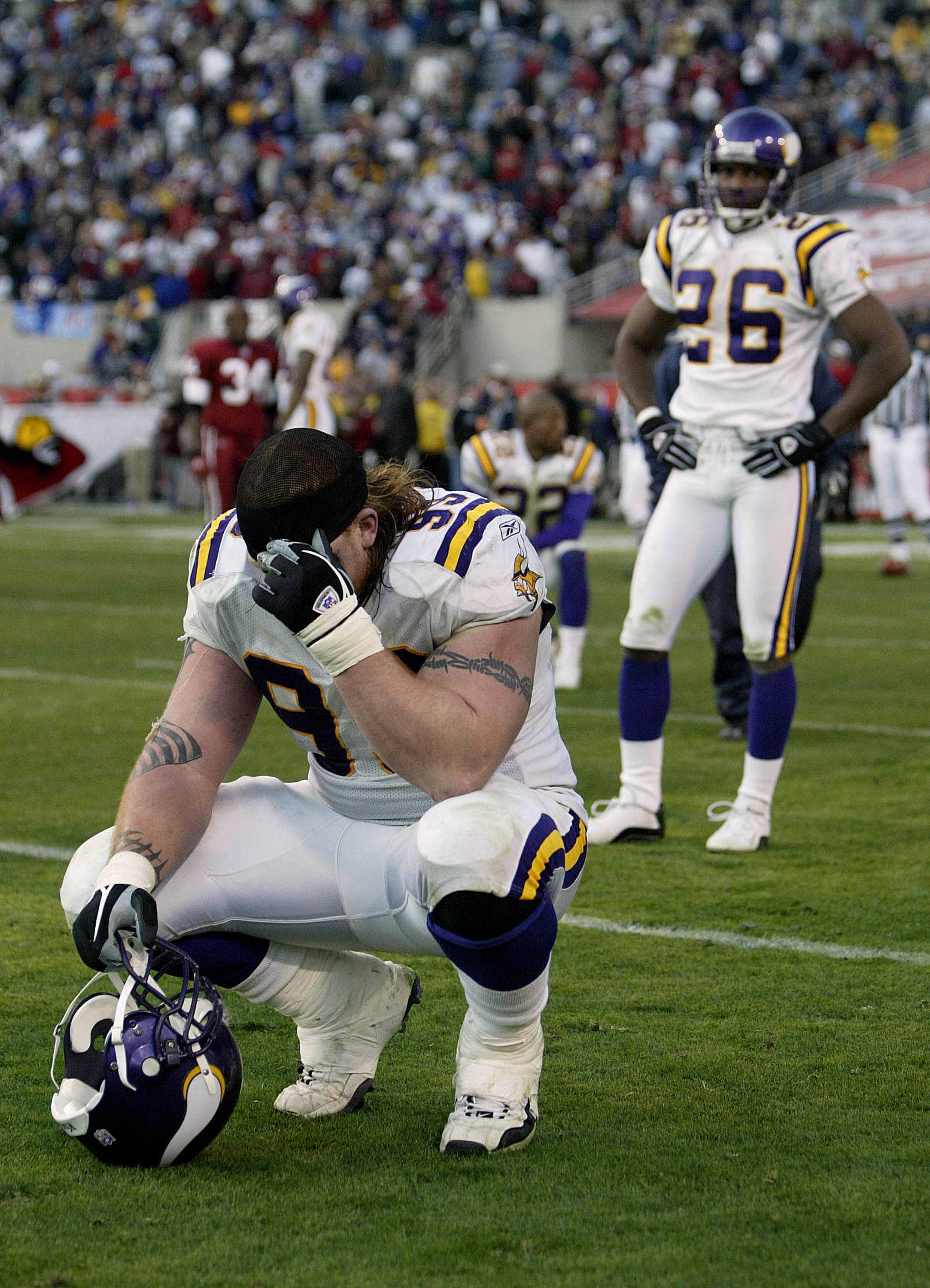 TEMPE, AZ - DECEMBER 28:   Chris Hovan #99 (L) of the Minnesota Vikings is dejected along with teammates Denard Walker #26 and Ken Irvin #22 after losing in the closing seconds 18-17 to the Arizona Cardinals during their game on December 28, 2003 at Sun D