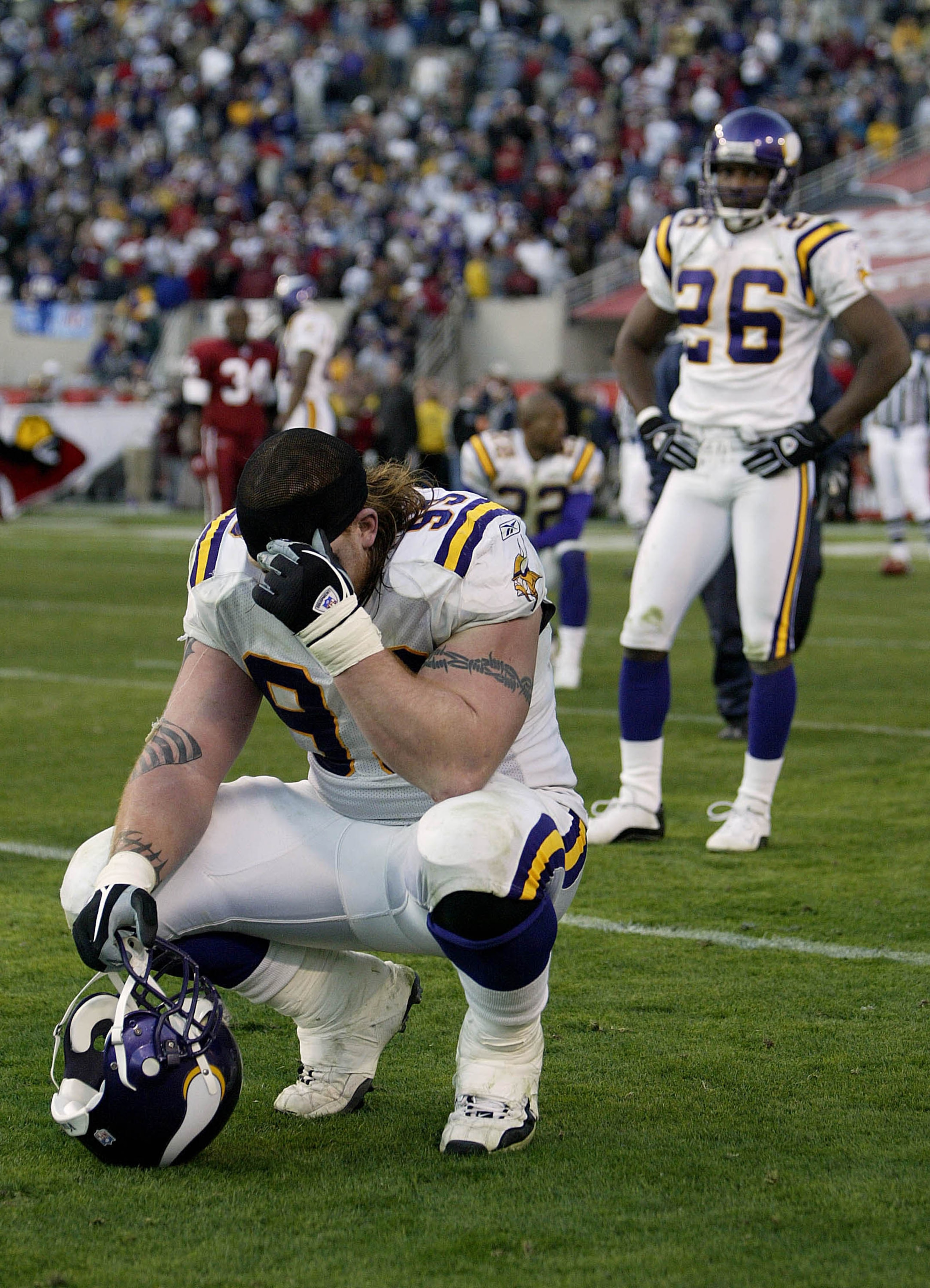 TEMPE, AZ - DECEMBER 28:   Chris Hovan #99 (L) of the Minnesota Vikings is dejected along with teammates Denard Walker #26 and Ken Irvin #22 after losing in the closing seconds 18-17 to the Arizona Cardinals during their game on December 28, 2003 at Sun D
