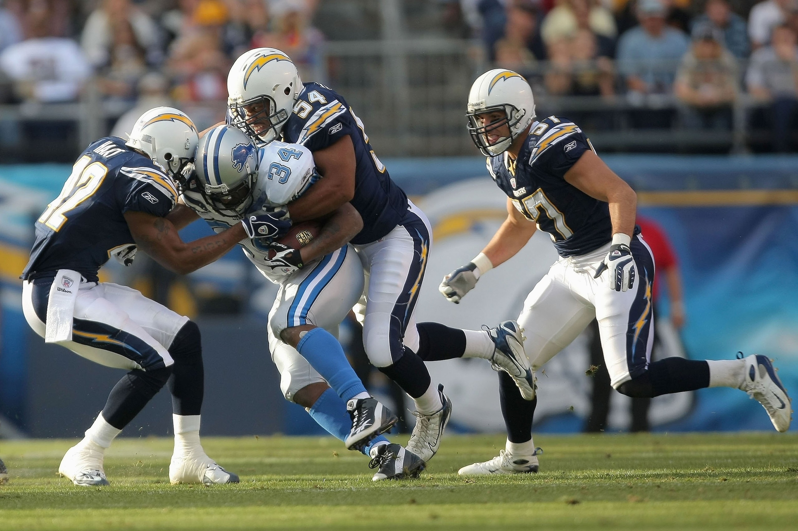 SAN DIEGO, CA - DECEMBER 16:  Stephen Cooper #54 and Clinton Hart #42 of the San Diego Chargers tackle Kevin Jones #34 of the Detroit Lions on December 16, 2007 at Qualcomm Stadium in San Diego, California.  (Photo by Harry How/Getty Images)