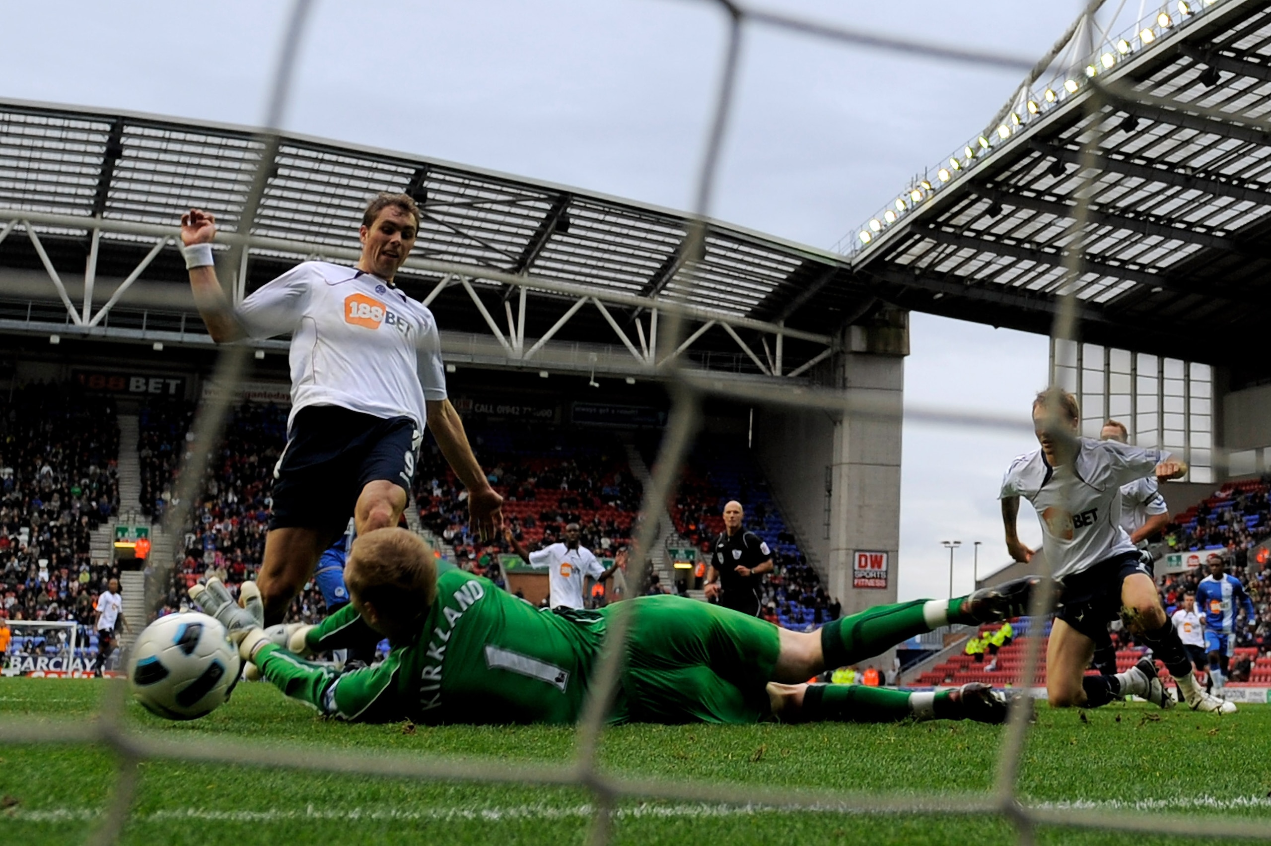 WIGAN, ENGLAND - OCTOBER 23:  Johan Elmander of Bolton Wanderers scores his team's first goal past Chris Kirkland of Wigan Athletic during the Barclays Premier League match between Wigan Athletic and Bolton Wanderers at the DW Stadium on October 23, 2010