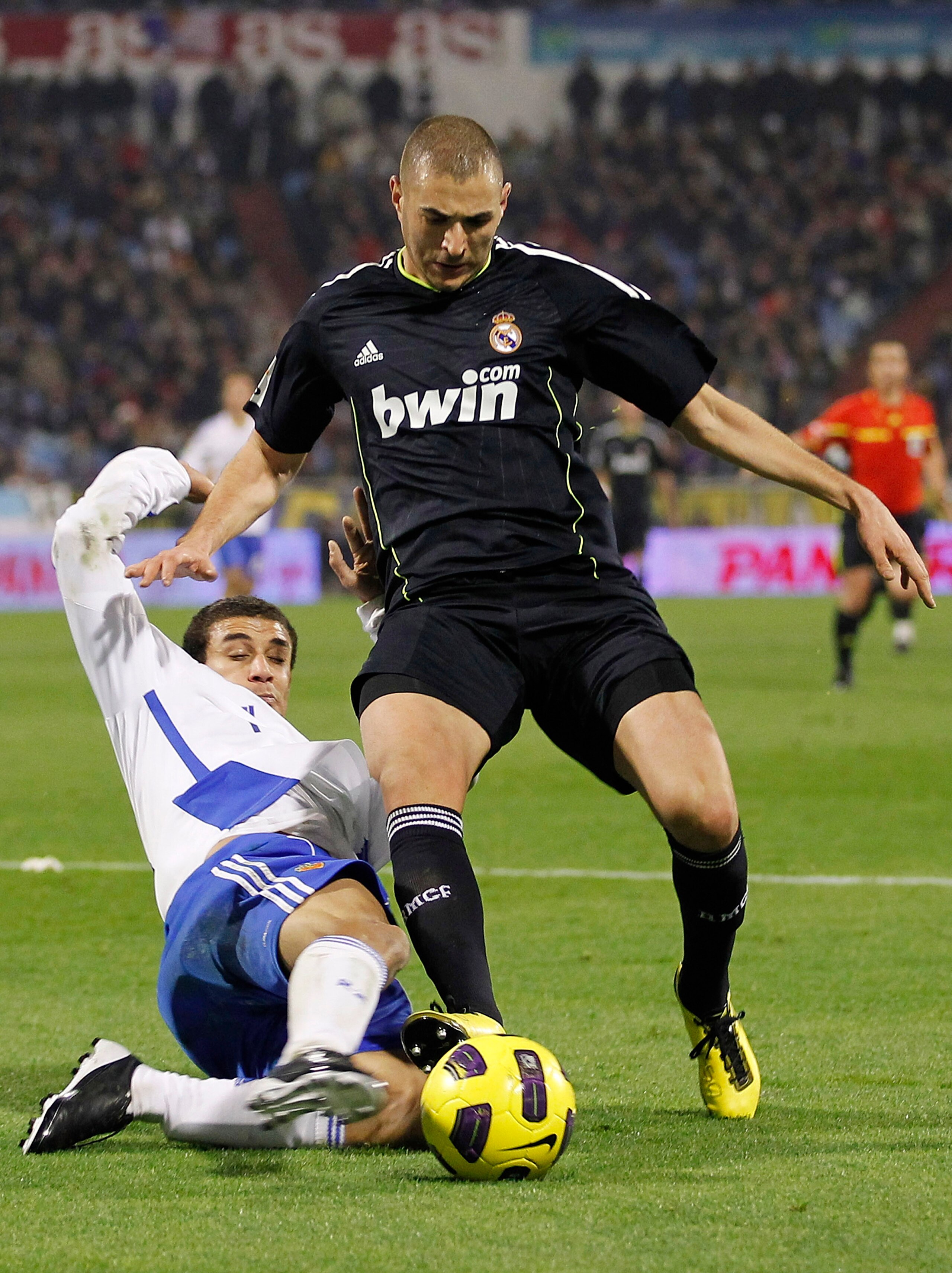 ZARAGOZA, SPAIN - DECEMBER 12:  Karim Benzema of Real Madrid is challenged by Carlos Diogo of Zaragoza during the La Liga match between Real Zaragoza and Real Madrid at La Romareda stadium on December 12, 2010 in Zaragoza, Spain.  (Photo by Angel Martinez