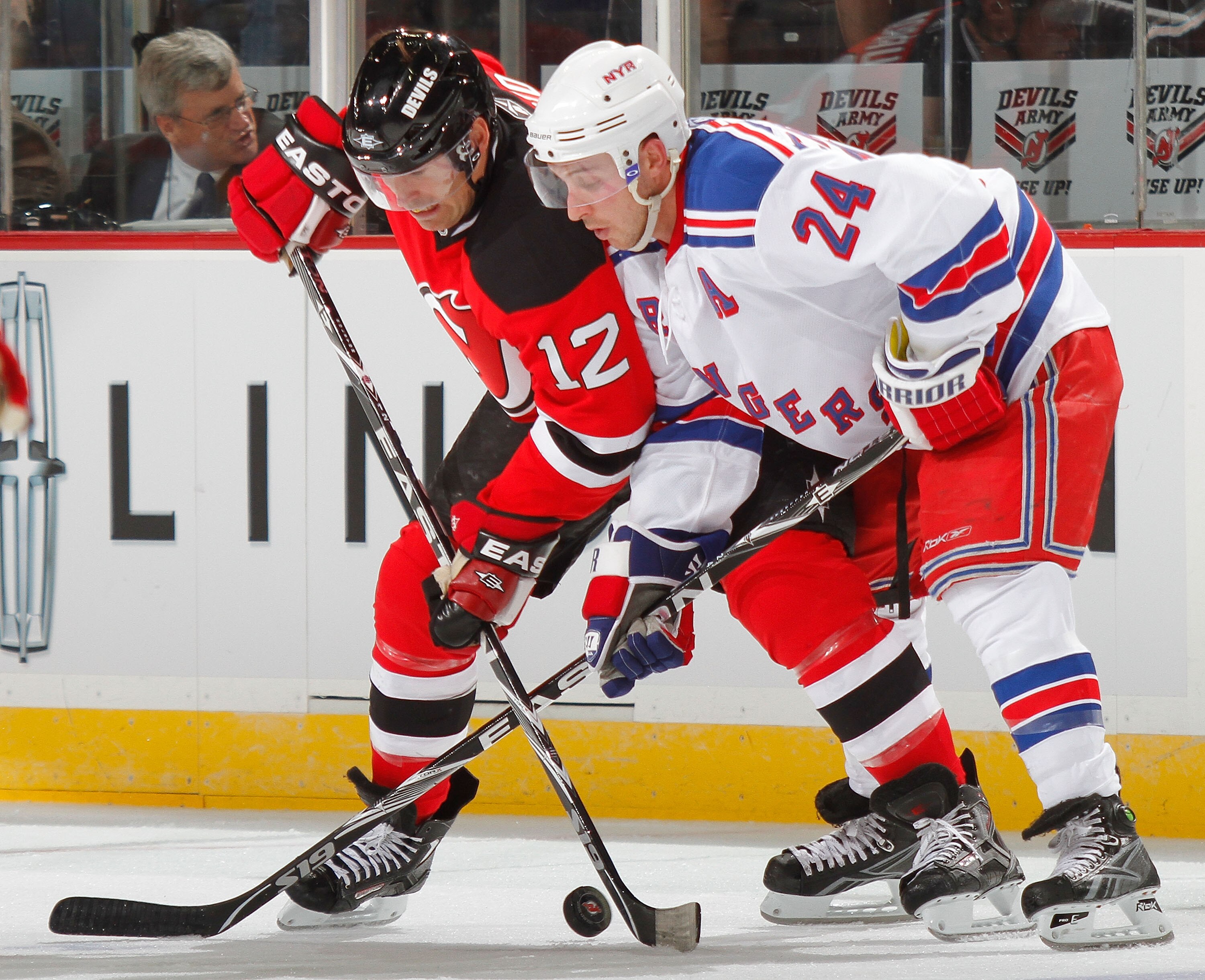 NEWARK, NJ - SEPTEMBER 25: Ryan Callahan #24 of the New York Rangers battles for the puck with Brian Rolston #12 of the New Jersey Devils in a preseason hockey game at the Prudential Center on September 25, 2010 in Newark, New Jersey.  (Photo by Paul Bere